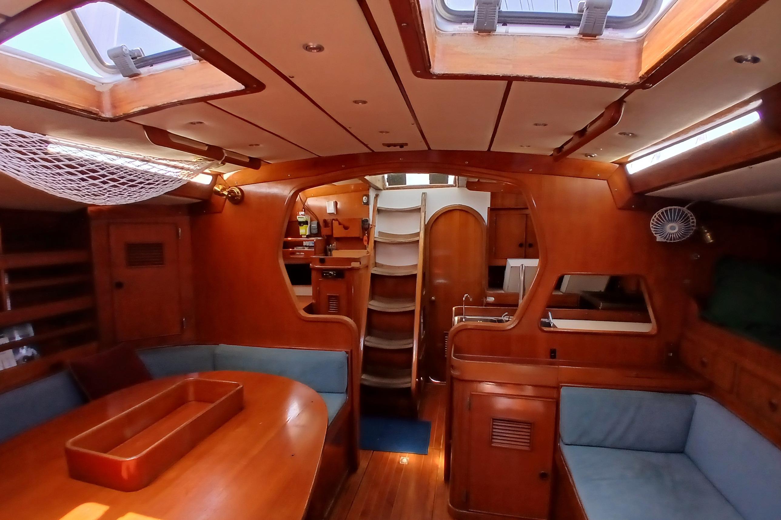 Interior of a 1981 SKYE 51 yacht with wooden furnishings and cozy seating.