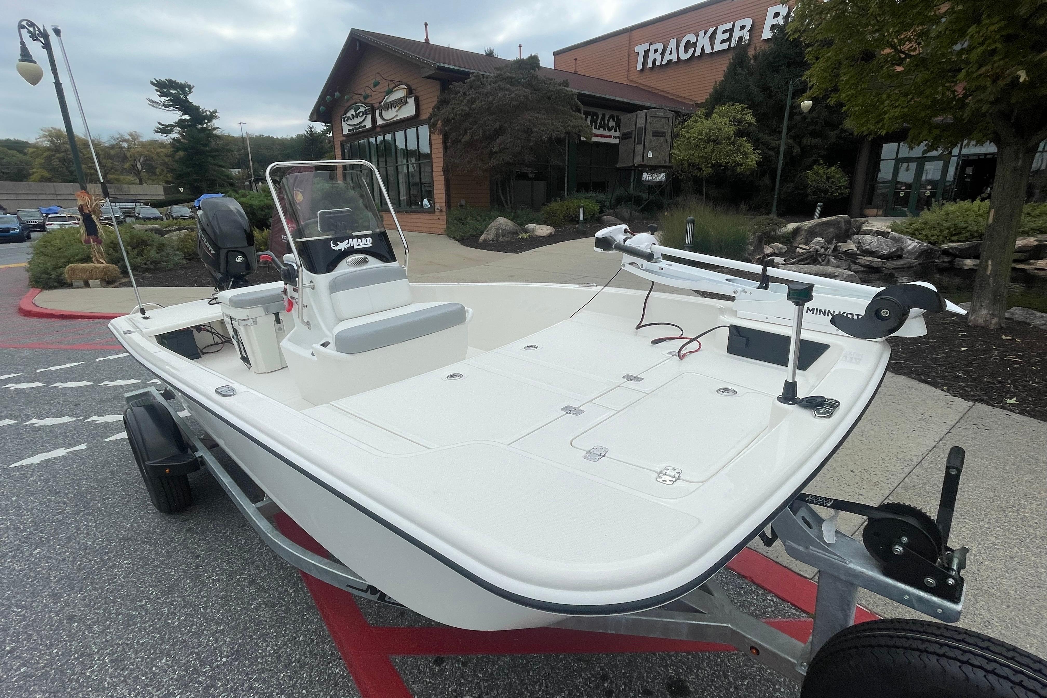 2026 Mako Pro Skiff 15 CC boat on trailer outside Tracker Boats store.