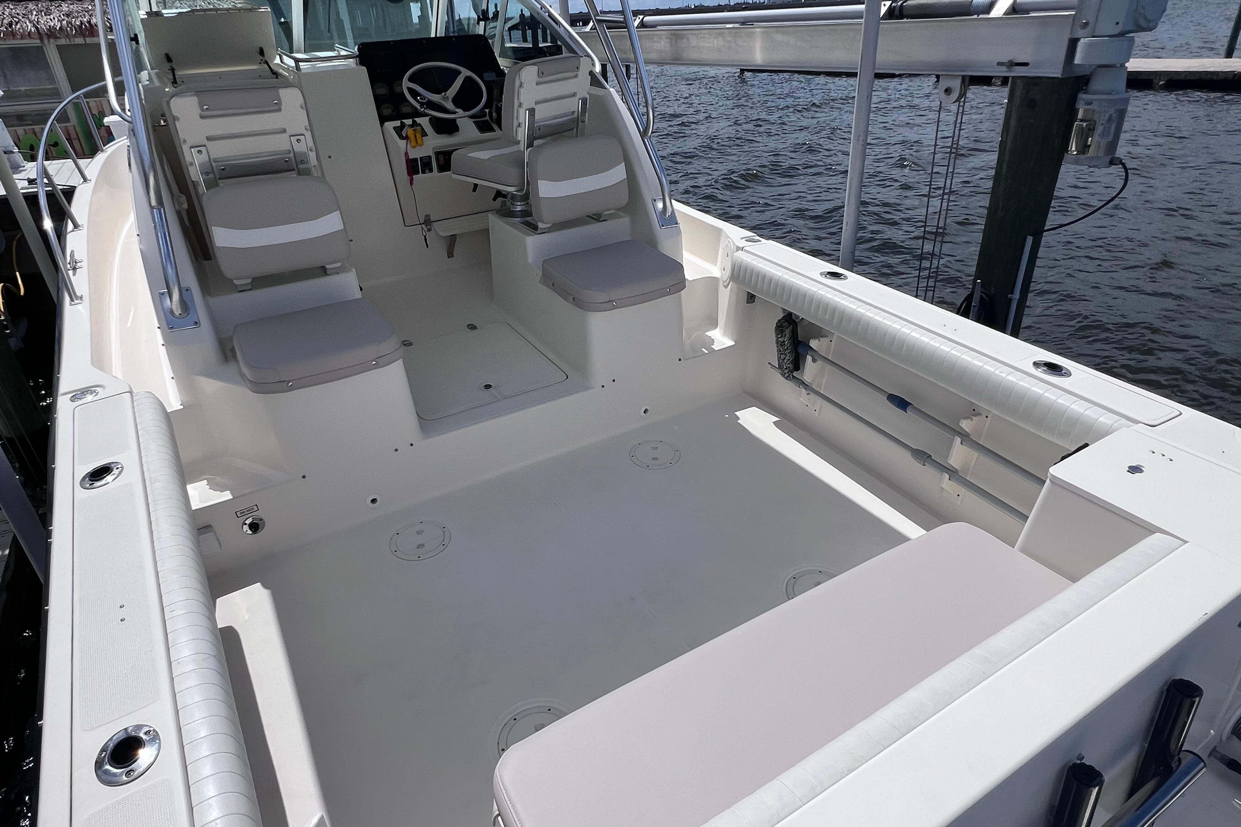 2004 Pursuit 2870 Walkaround boat interior with seating and steering wheel, docked by the water.