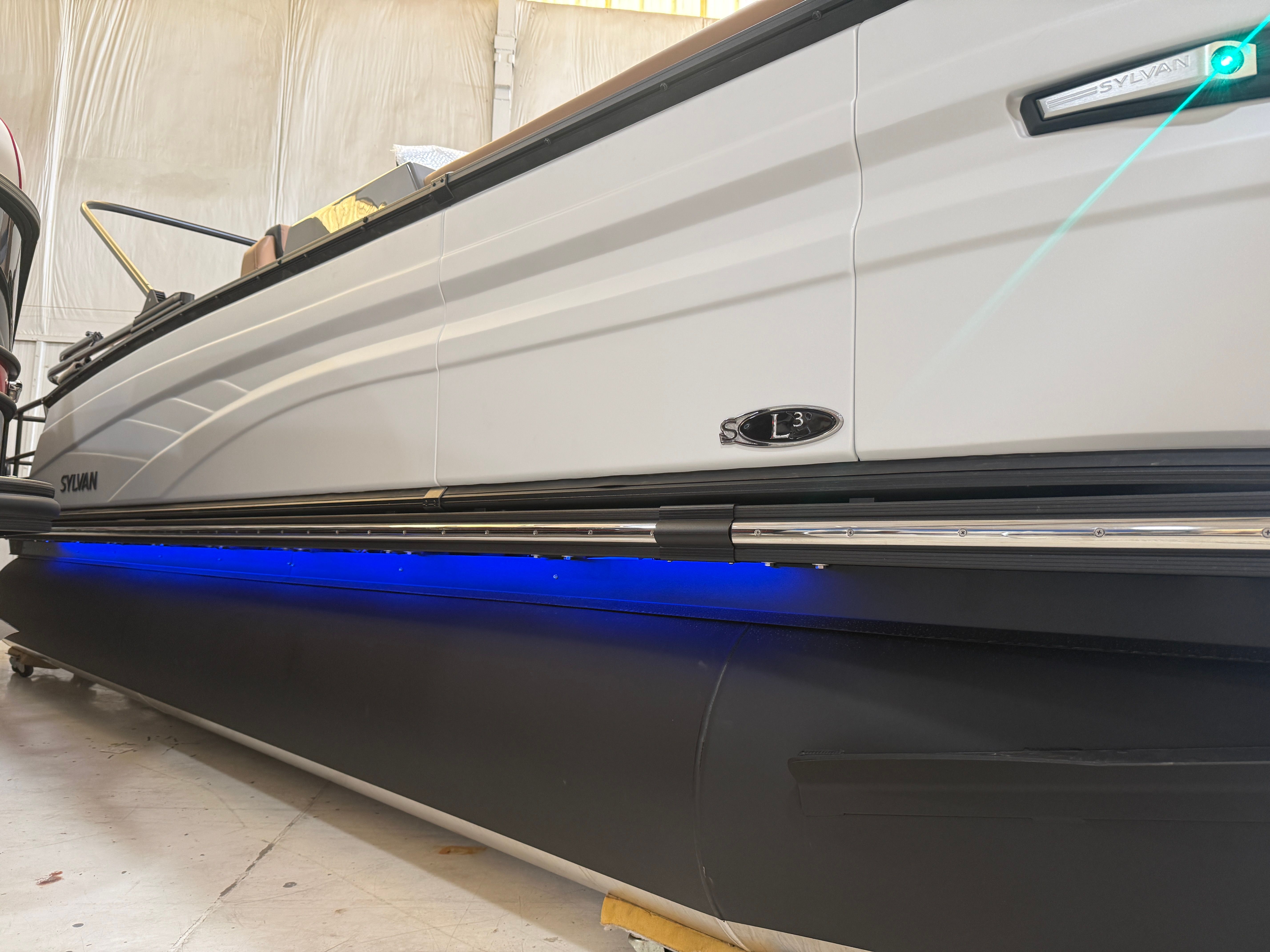 A modern 2026 Sylvan L3 ULZ DH boat with blue underglow lighting.