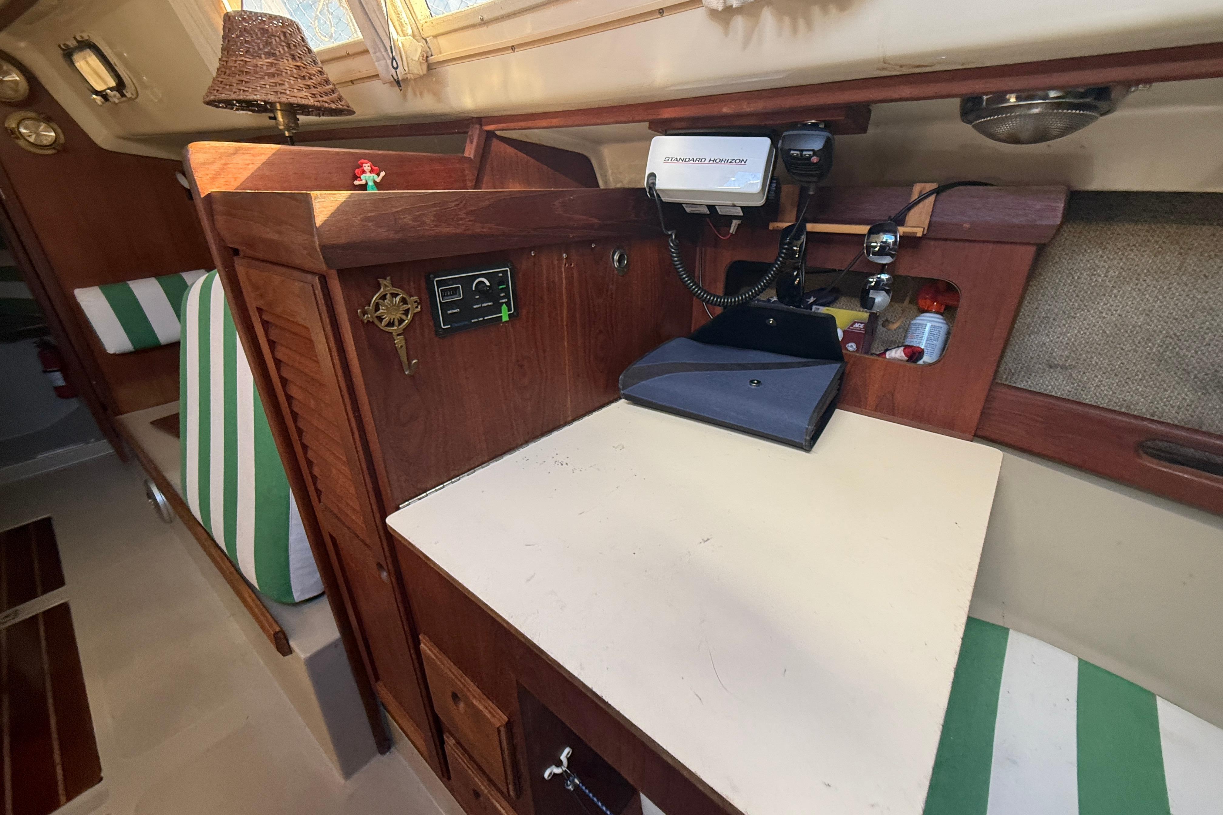 Interior of 1983 O'Day 34 sailboat with navigation station and striped seating.