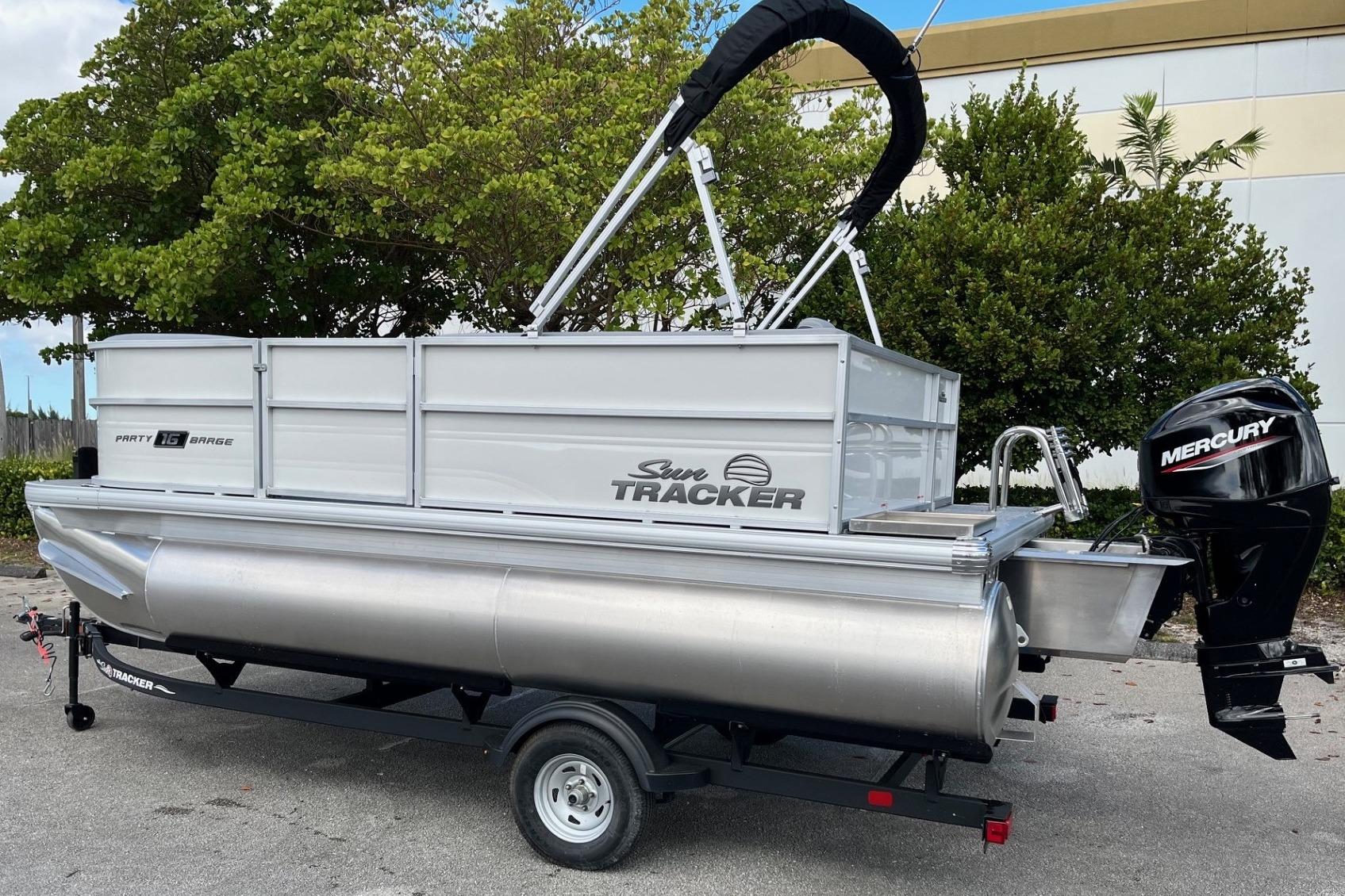 2026 Sun Tracker Party Barge 16 DLX pontoon boat with Mercury outboard motor on trailer.