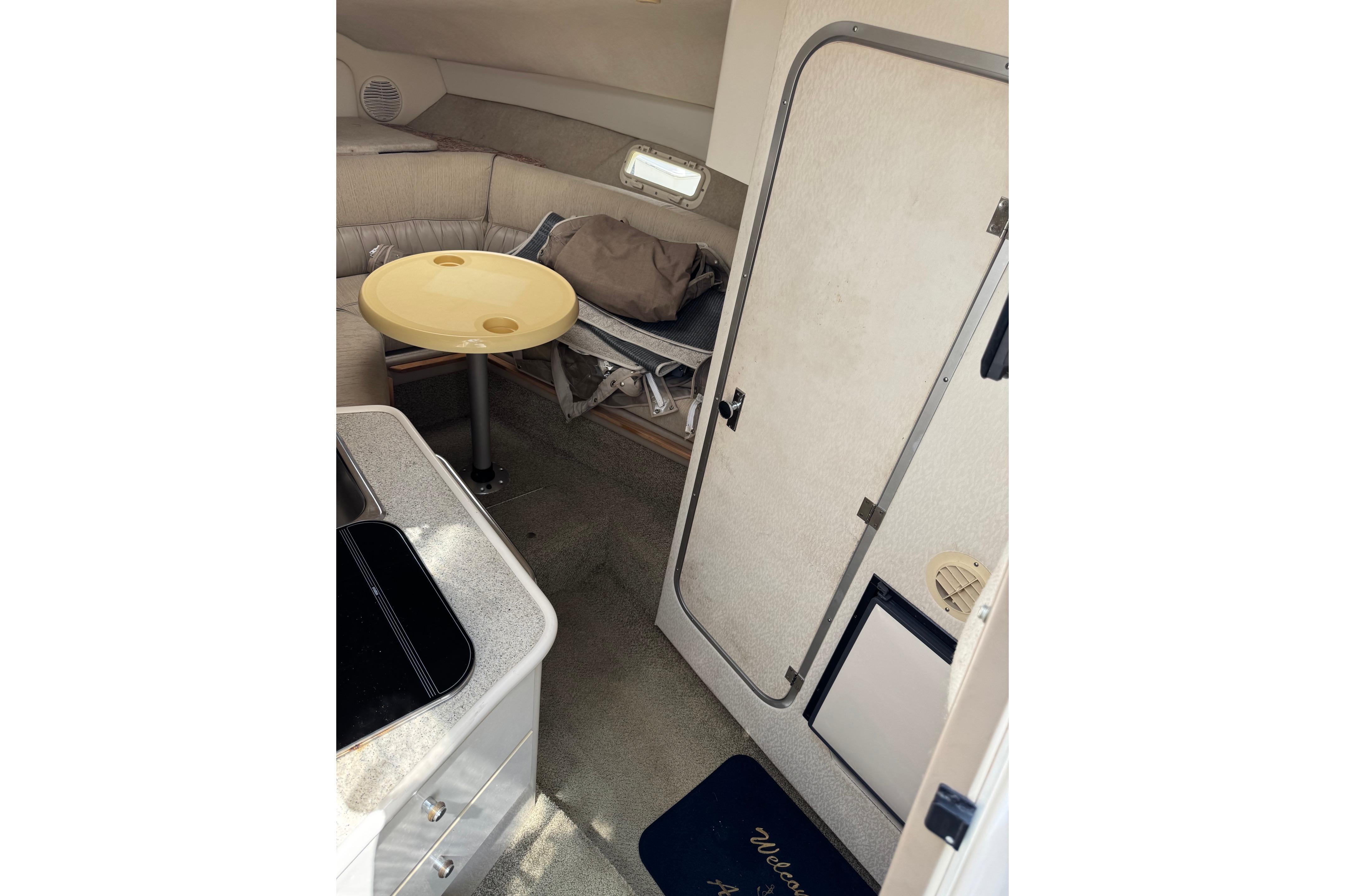Interior of 2000 Maxum 2400 SCR boat with seating area and compact table.
