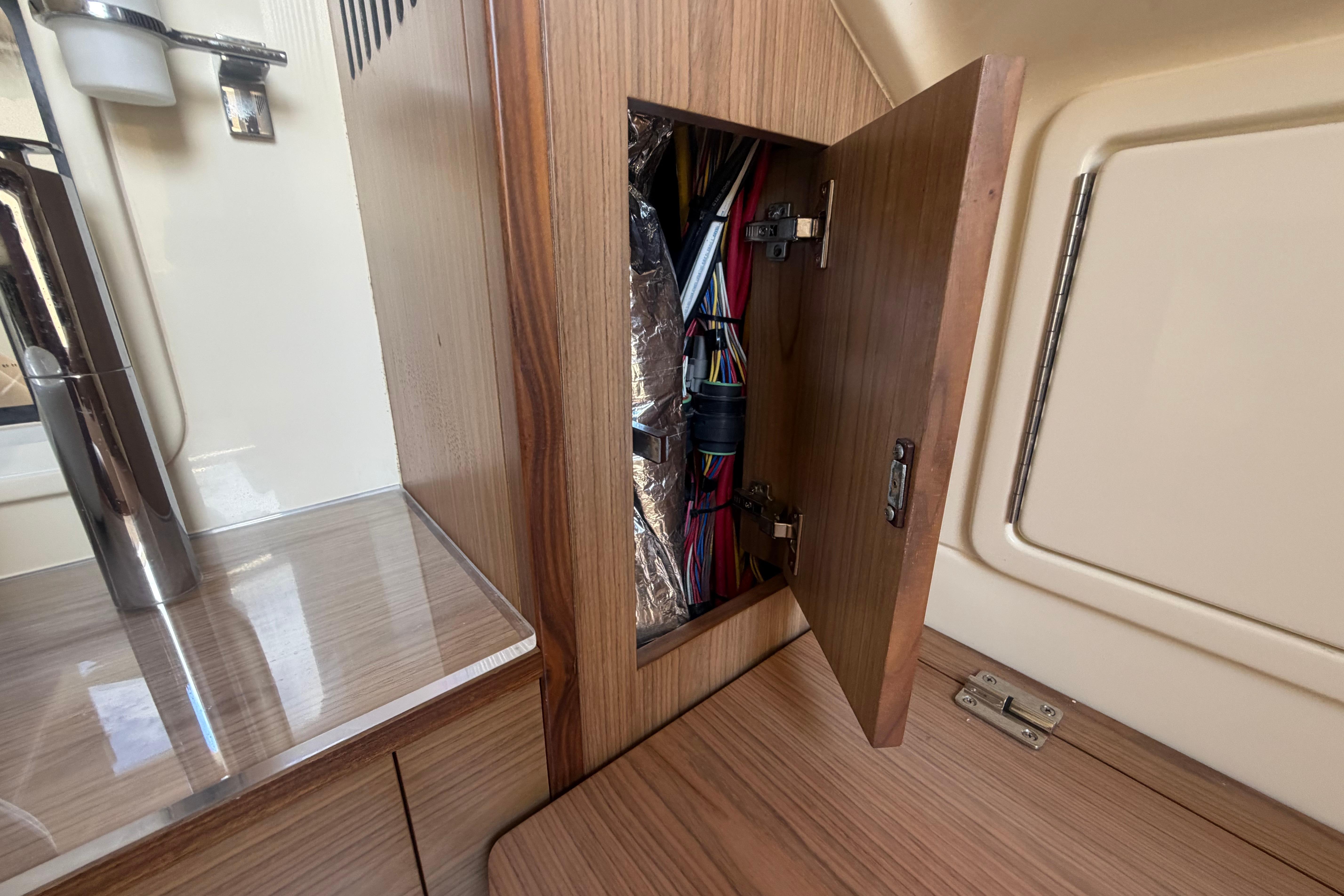 Open cabinet revealing wiring inside a 2017 Chris-Craft Catalina 34 boat interior.