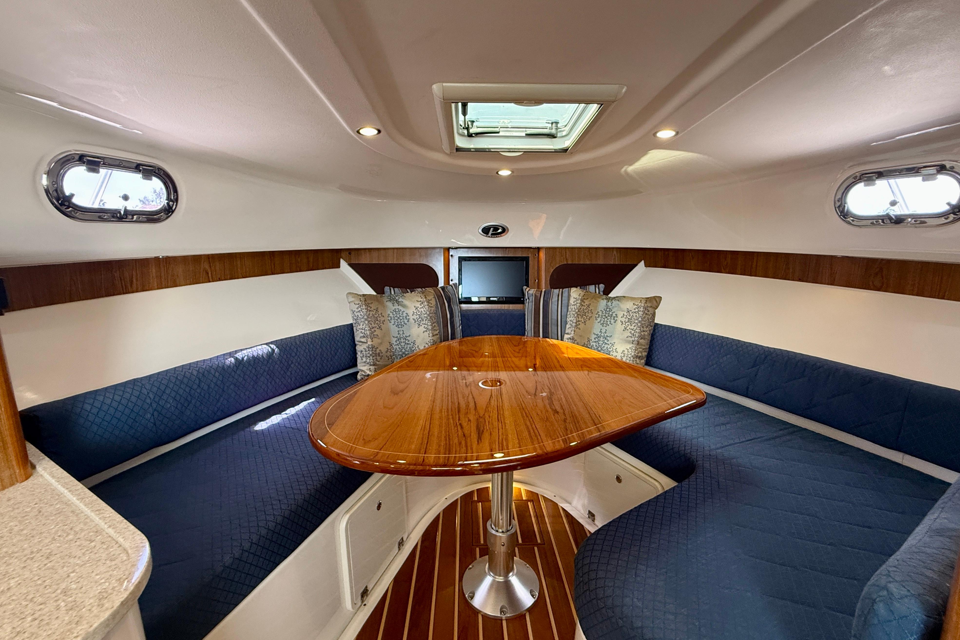 Luxurious interior of 2012 Pursuit OS 345 Offshore boat with elegant seating and wooden table.