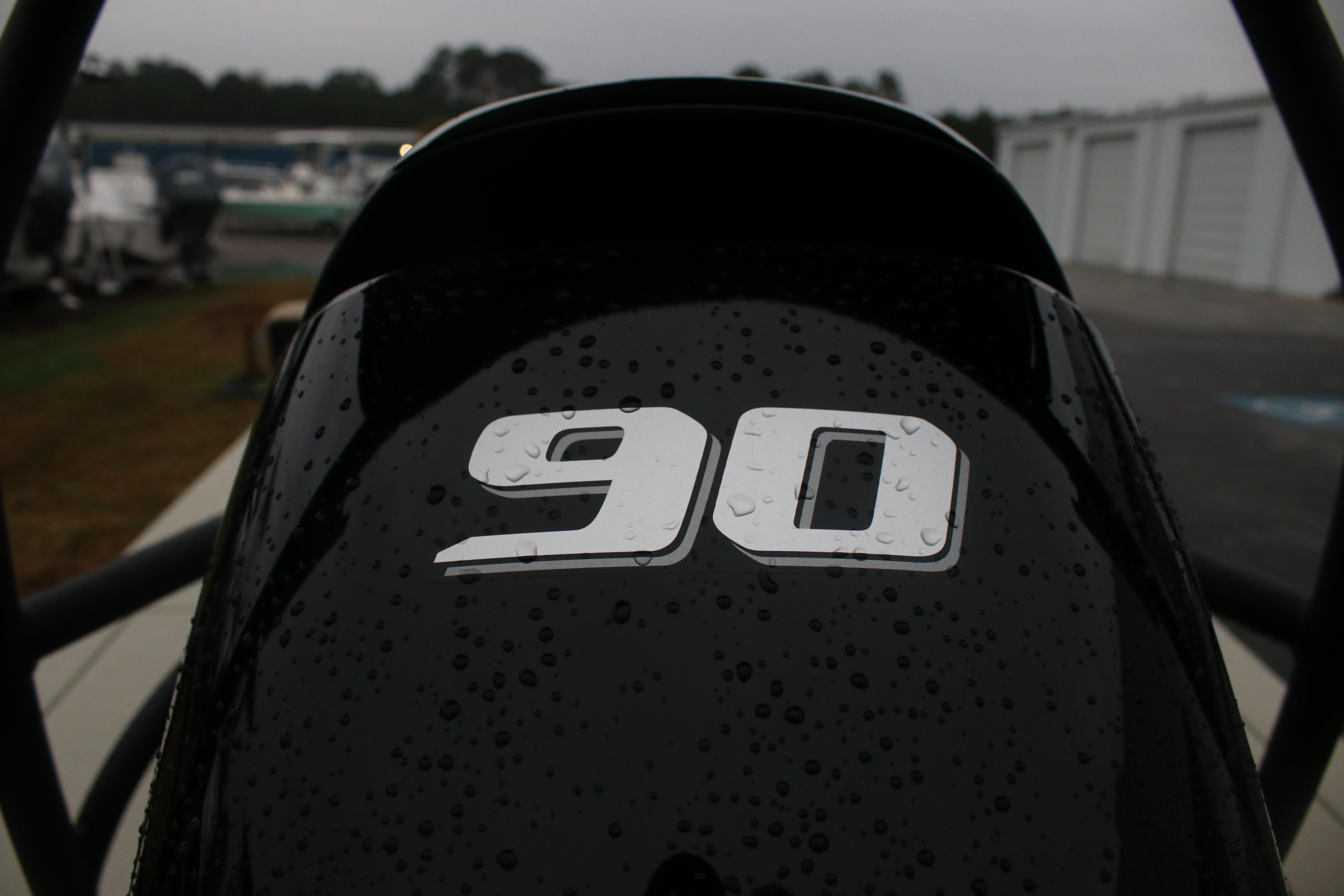 Close-up of 2026 East Cape EVO 18V with '90' decal, wet with raindrops.
