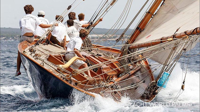 Sailors navigating a vintage 1898 Livingston Charles yacht on the ocean.
