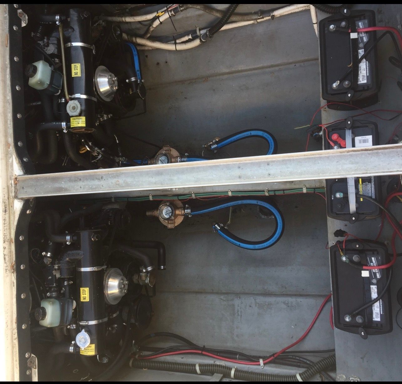 Engine compartment of a boat with two engines and batteries.