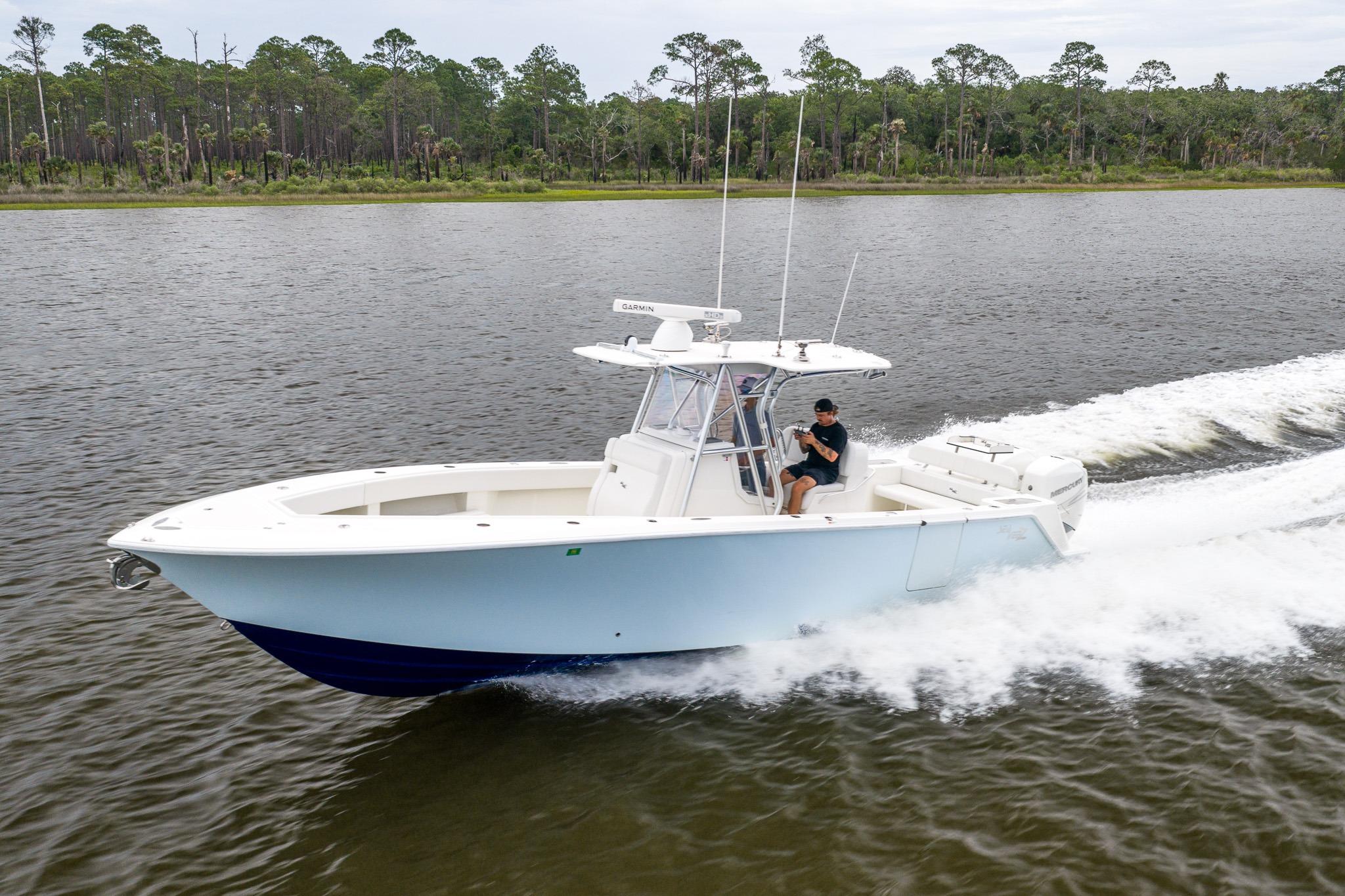 2019 SeaVee 322Z boat cruising on a calm river with lush forest backdrop.