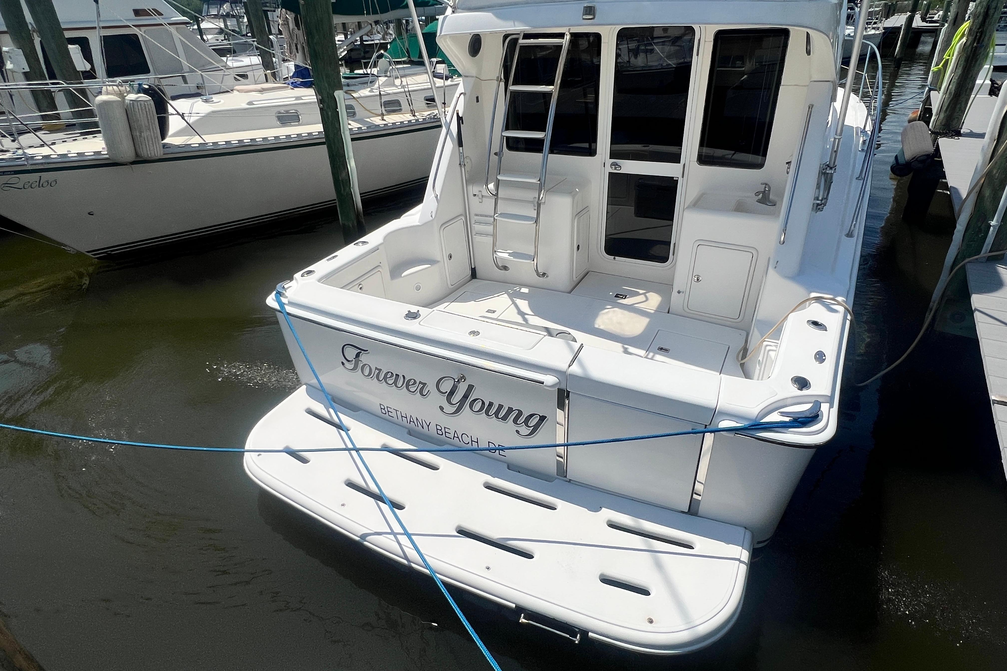 2007 Riviera 33 Flybridge yacht docked, named "Forever Young," at Bethany Beach marina.