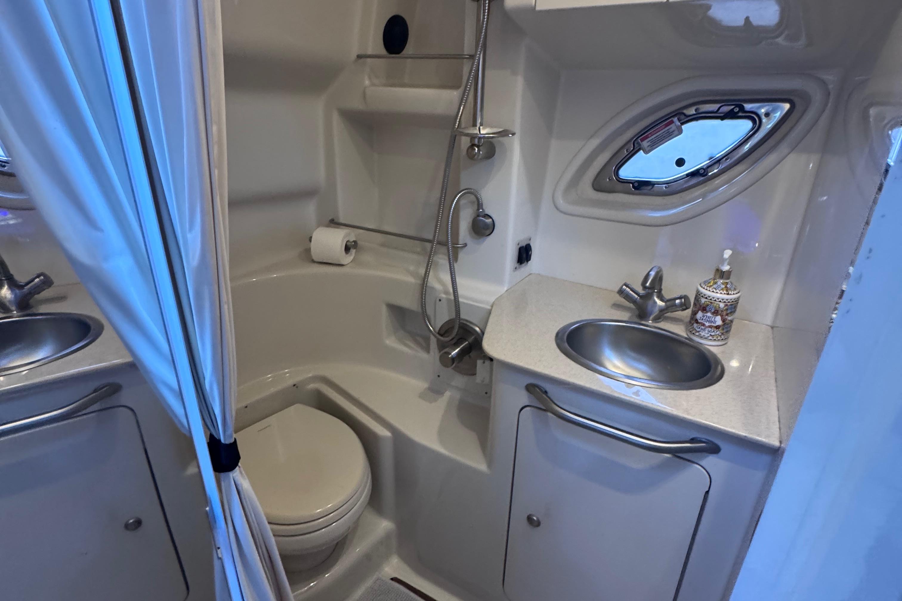 2008 Sea Ray 350 Sundancer bathroom with shower, sink, and porthole window.