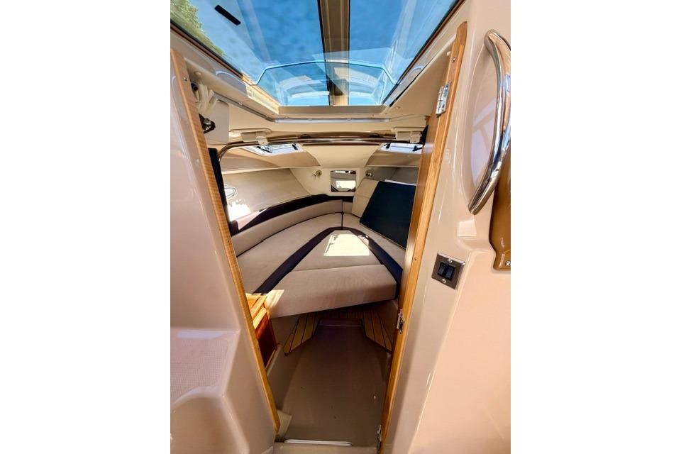 Interior view of 2017 Cutwater C-242 Coupe cabin with skylight and cozy seating.