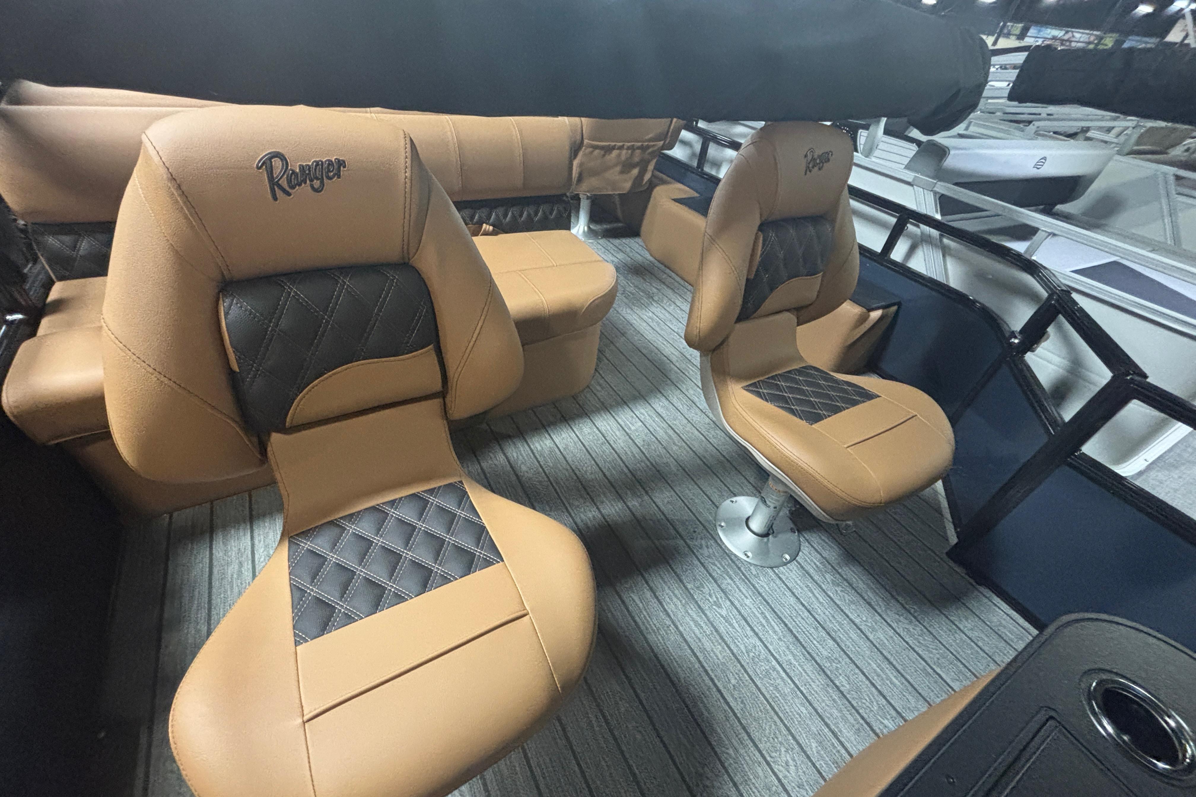 2026 Ranger 223F boat interior with tan and black cushioned seats.