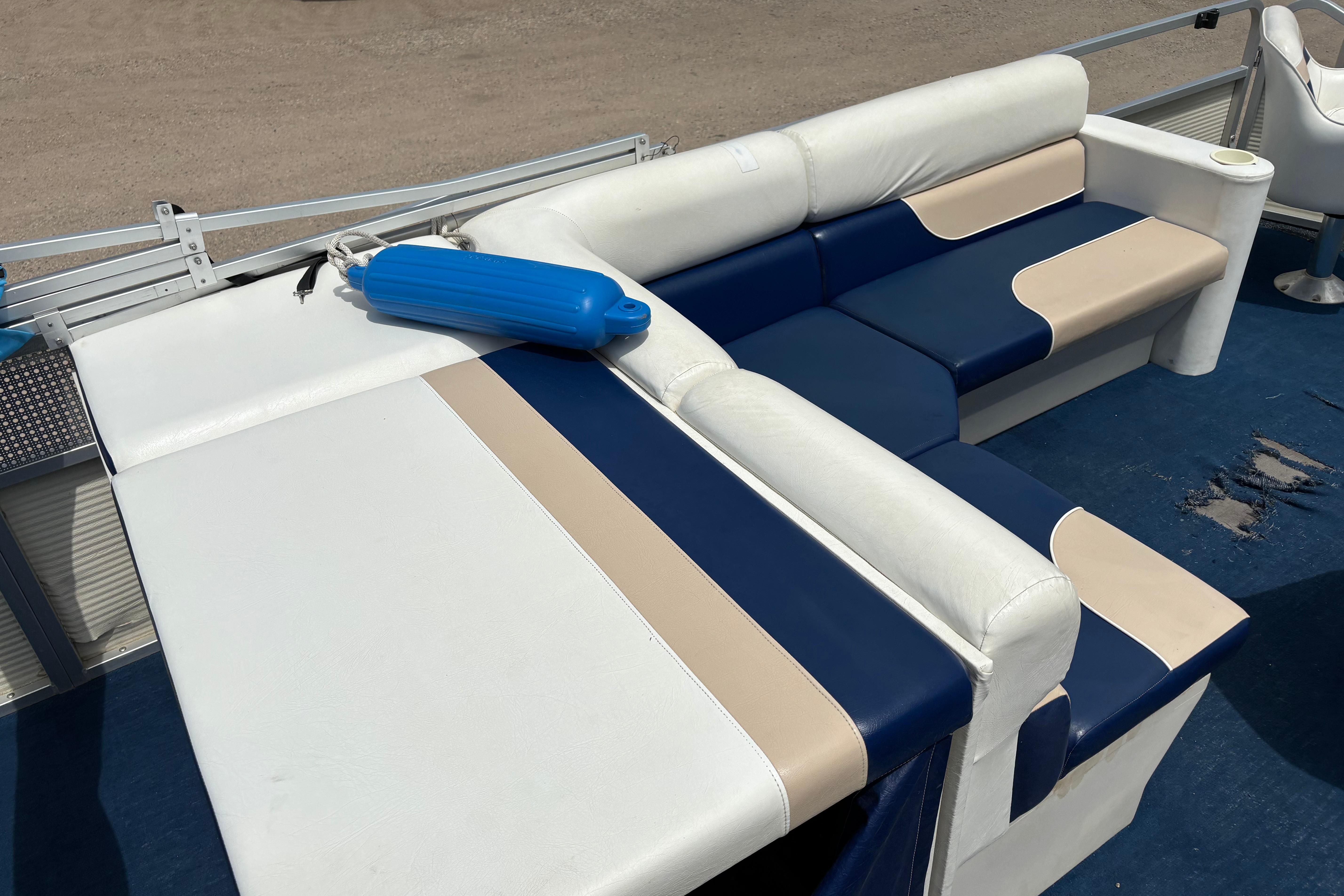 1997 Northwood 24' Pontoon boat interior with blue and beige seating, blue fender on deck.