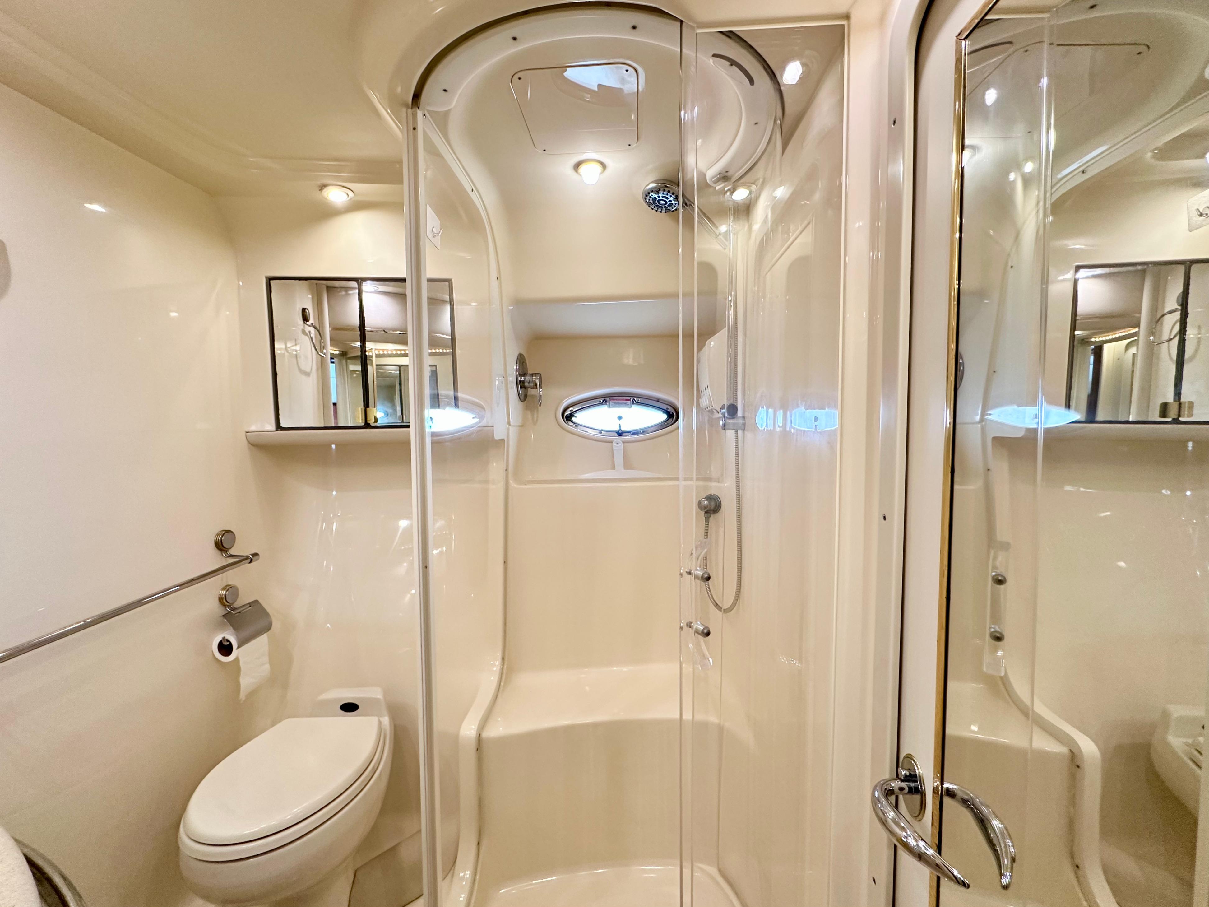Luxurious bathroom in 2002 Sea Ray 560 Sedan Bridge yacht, featuring shower and toilet.