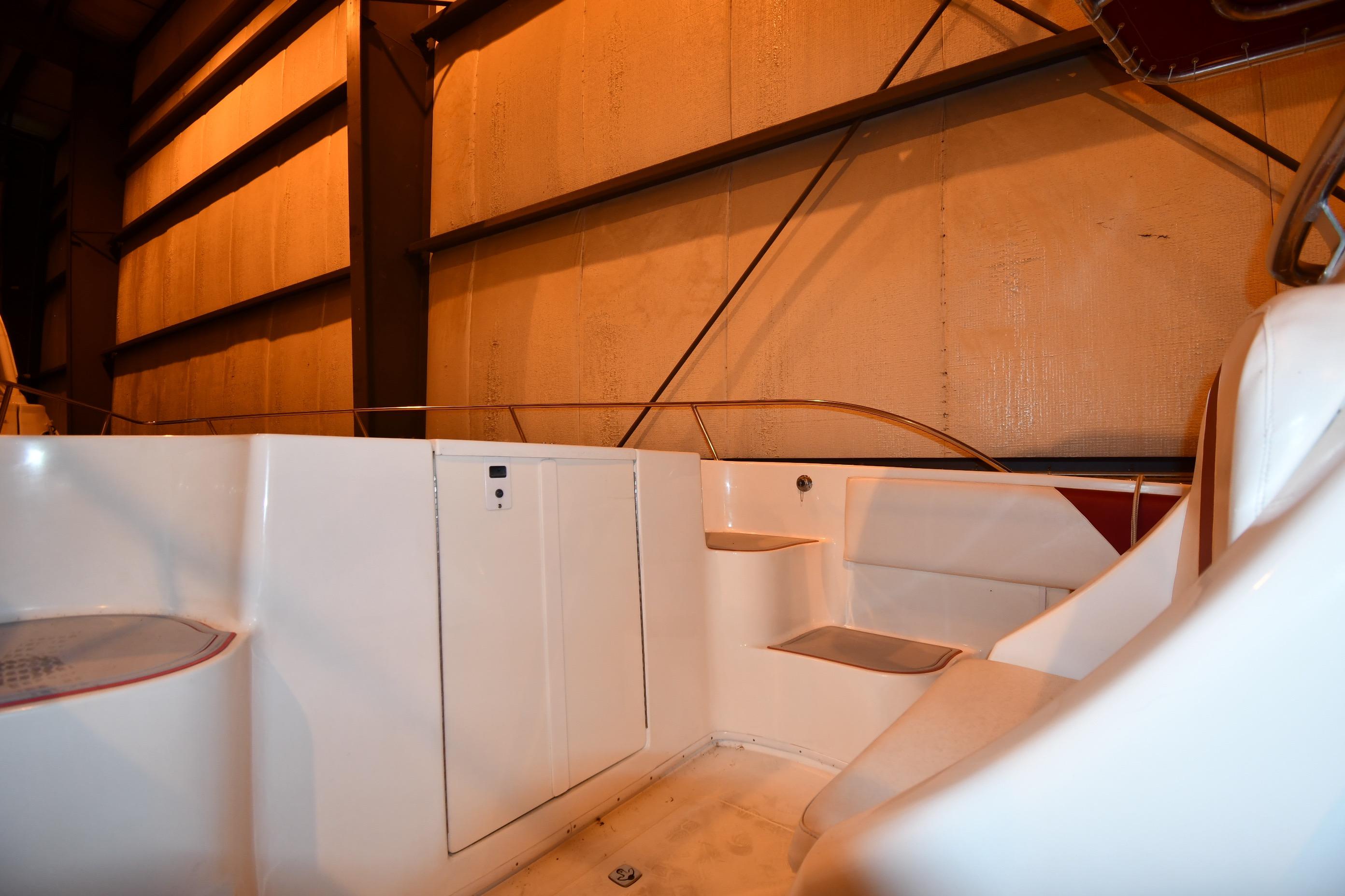 2001 Fountain 38 Center Console boat interior with seating and storage in a dimly lit space.
