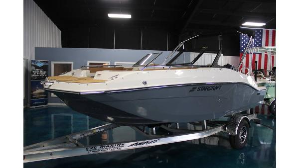 2025 Starcraft SVX 190 OB DC boat on trailer in showroom with American flag.