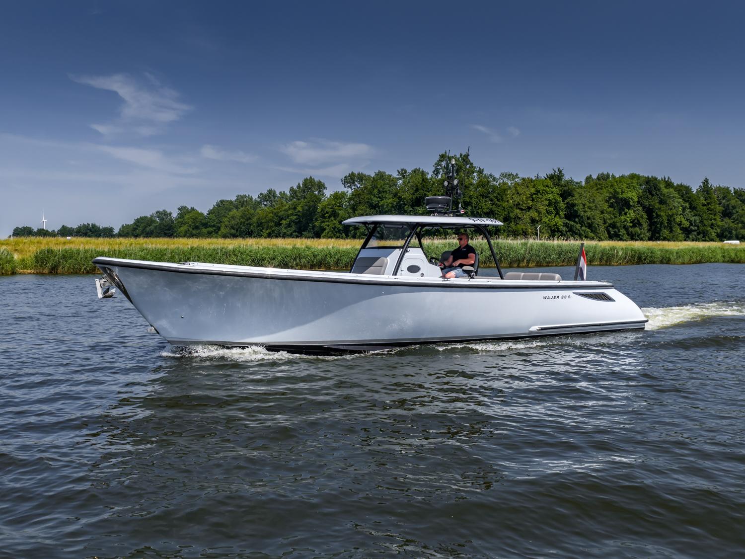 2017 Wajer 38 S boat cruising on a calm river with lush green trees.