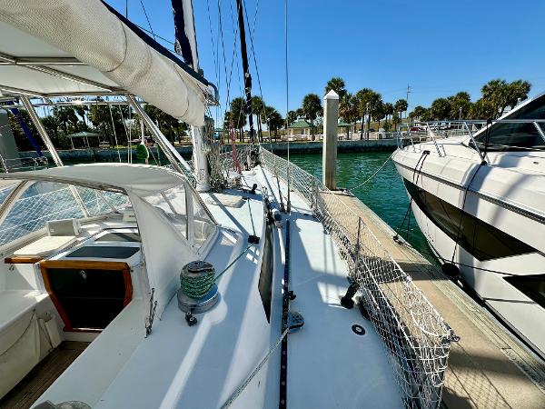 1989 Concordia 52 sailboat docked at marina with clear blue water and palm trees.