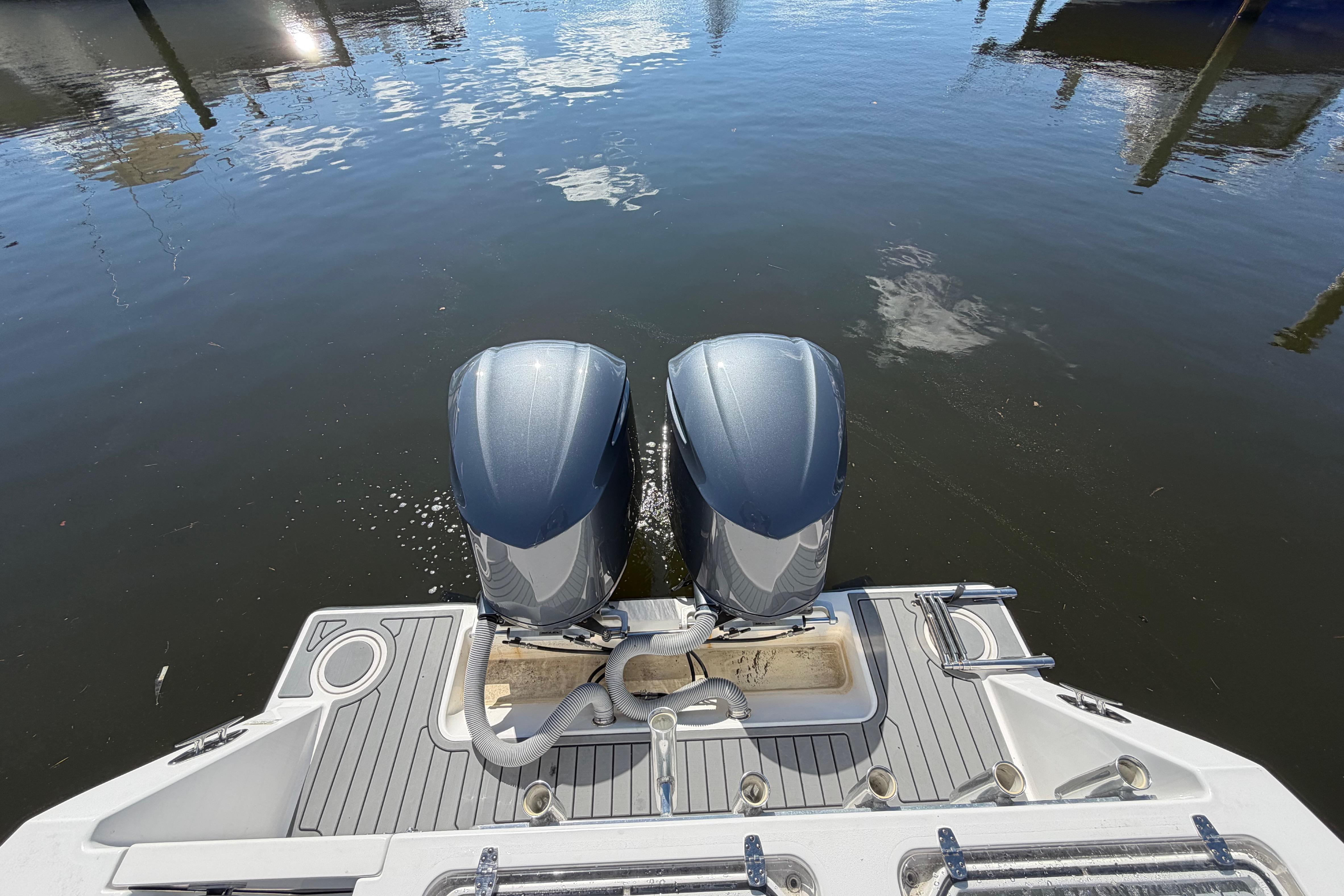 2015 Contender 32 ST boat with dual outboard motors on calm water.