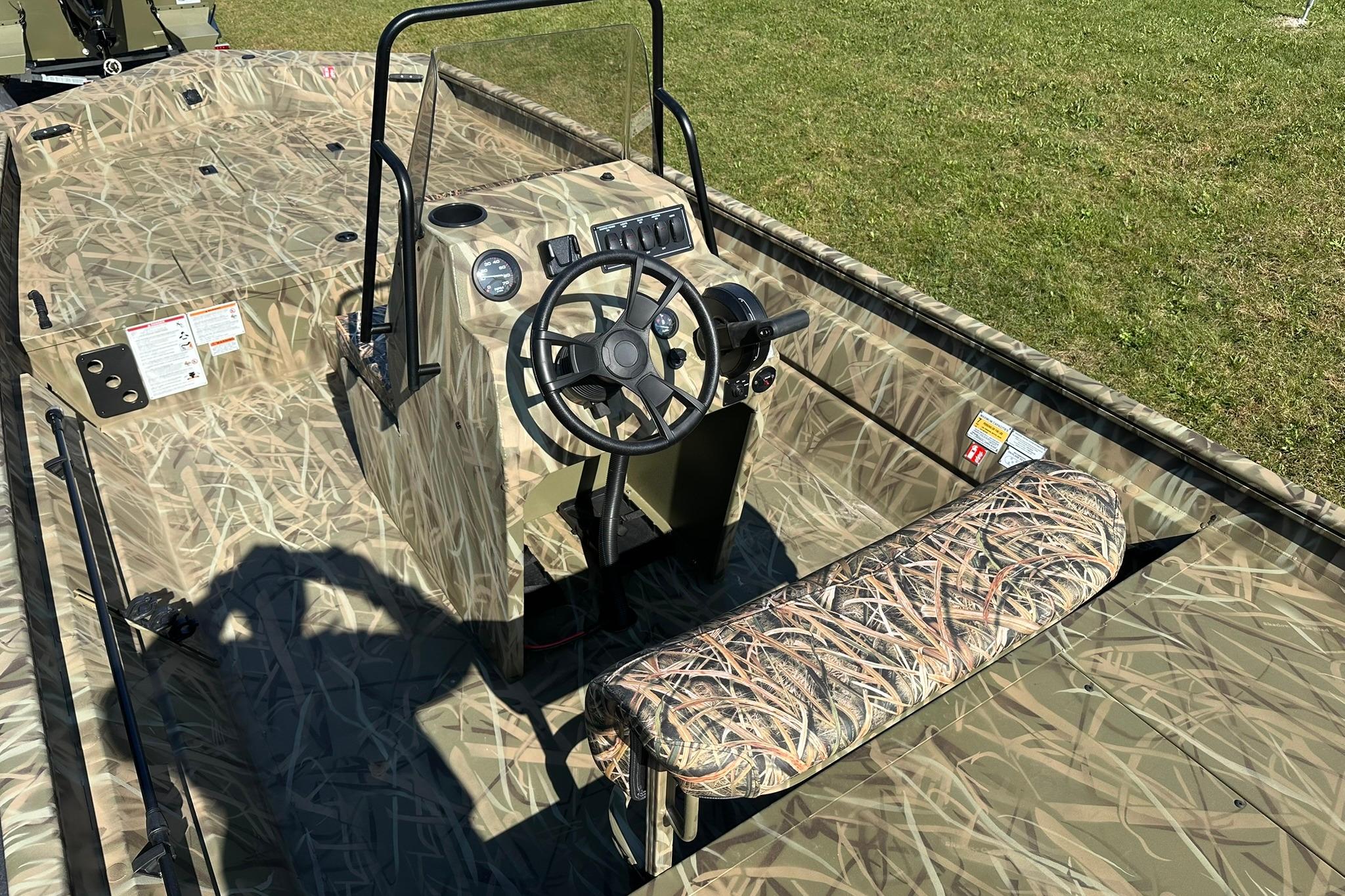 2026 Lowe Roughneck 2070CC boat with camouflage design, featuring a central console and steering wheel.