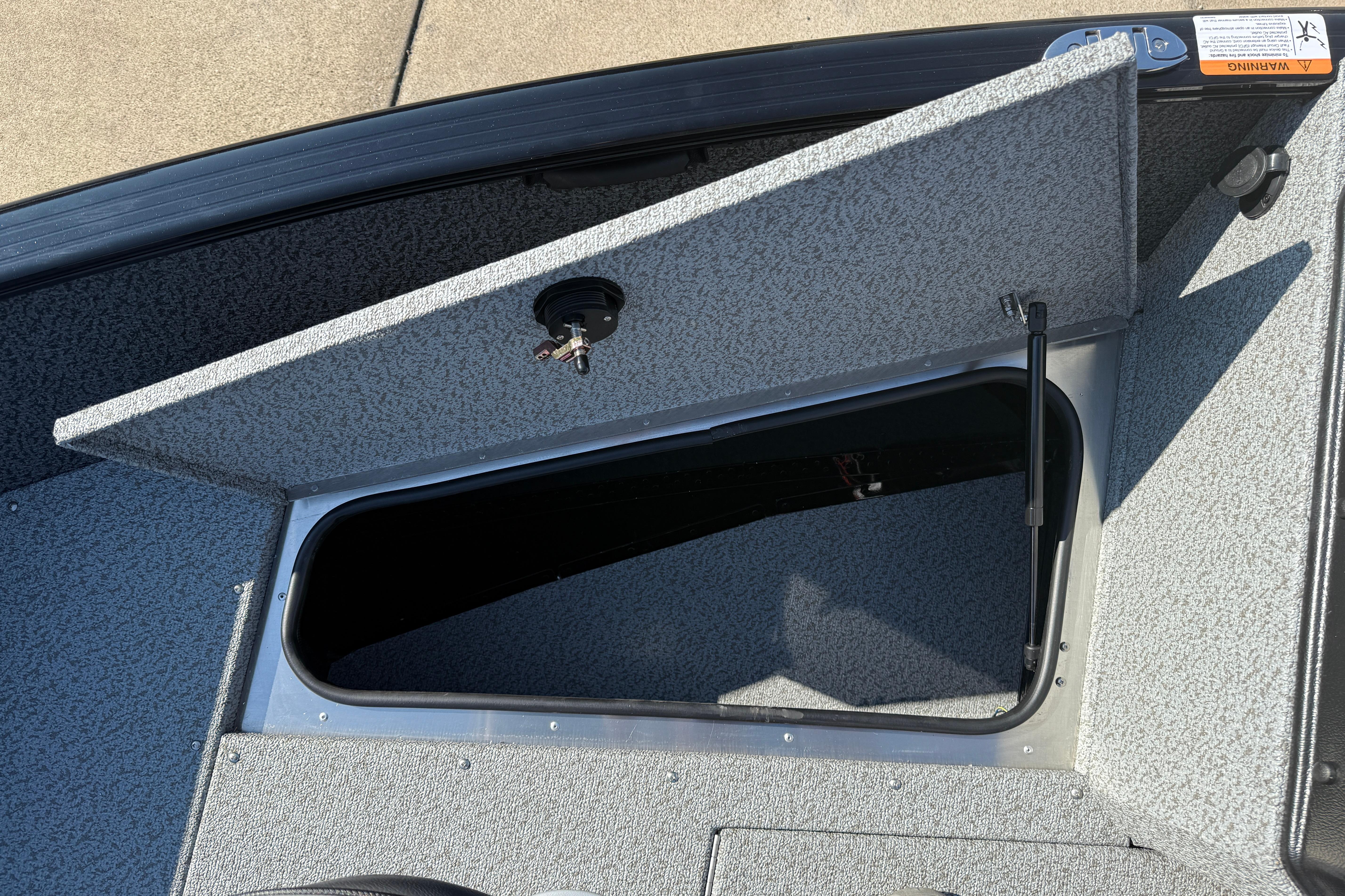 Open storage compartment on 2026 Lund 1675 Adventure SS boat, showcasing interior space.