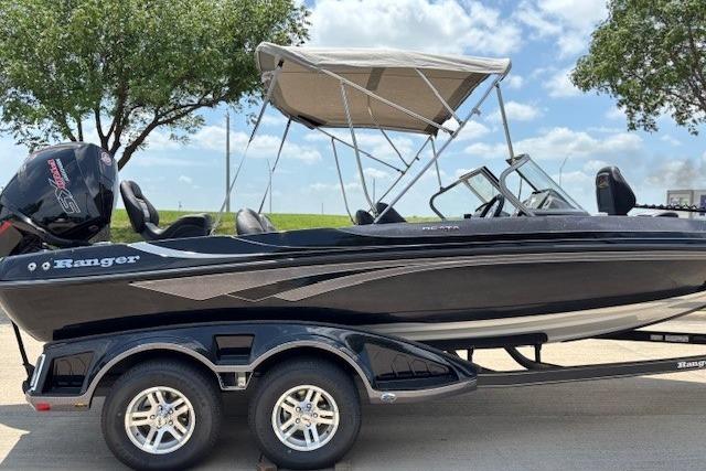 2026 Ranger 212LS boat with canopy on trailer, parked outdoors under blue sky.