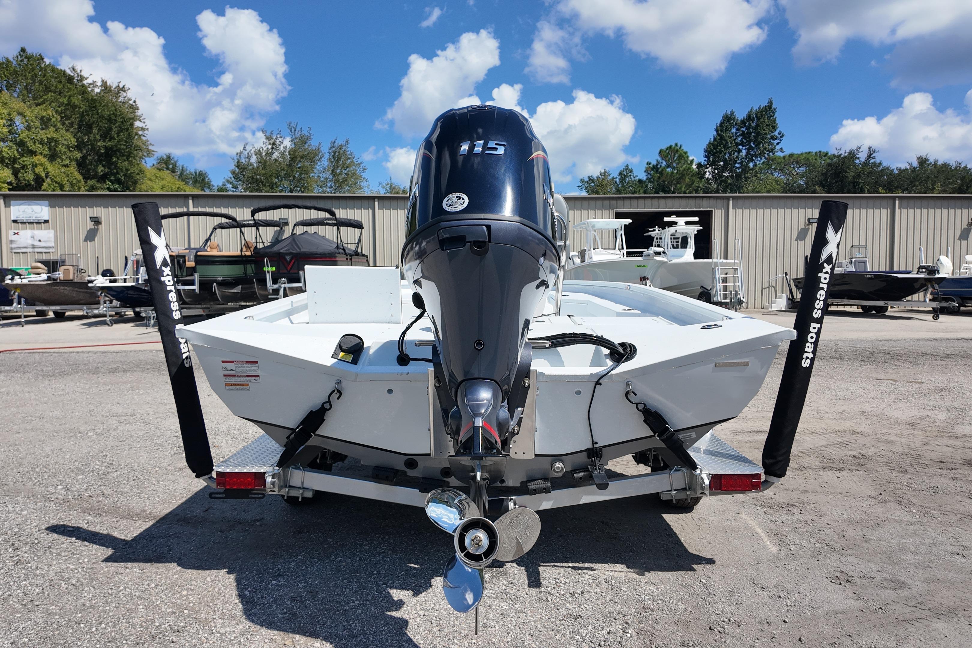 2026 Xpress H20 boat with powerful outboard motor, parked outdoors under a clear sky.
