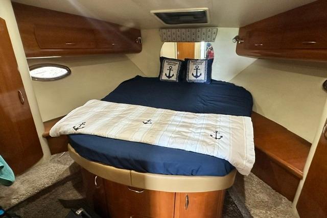 Cozy cabin interior of 2004 Carver 360 Mariner with nautical-themed bedding.