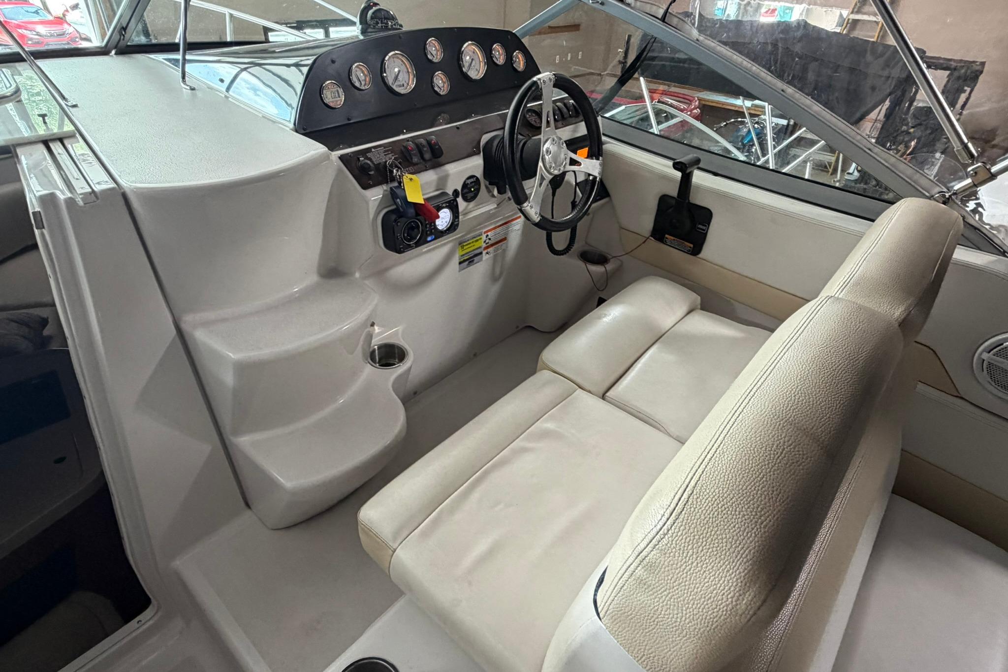 2008 Four Winns V248 boat interior with steering wheel and dashboard controls.