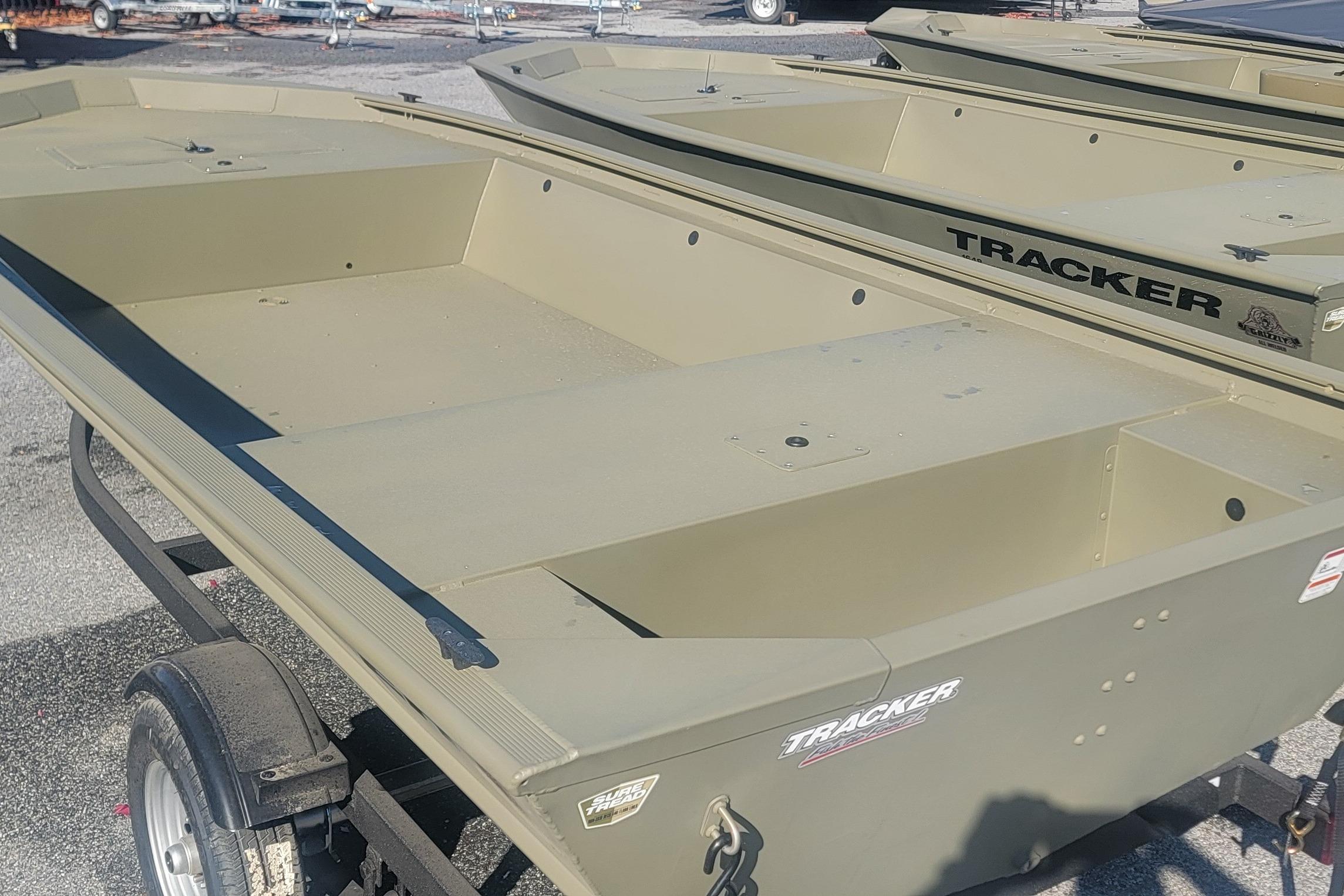 2026 Tracker Grizzly 1648 Utility boat in a parking lot, showcasing its sturdy design.