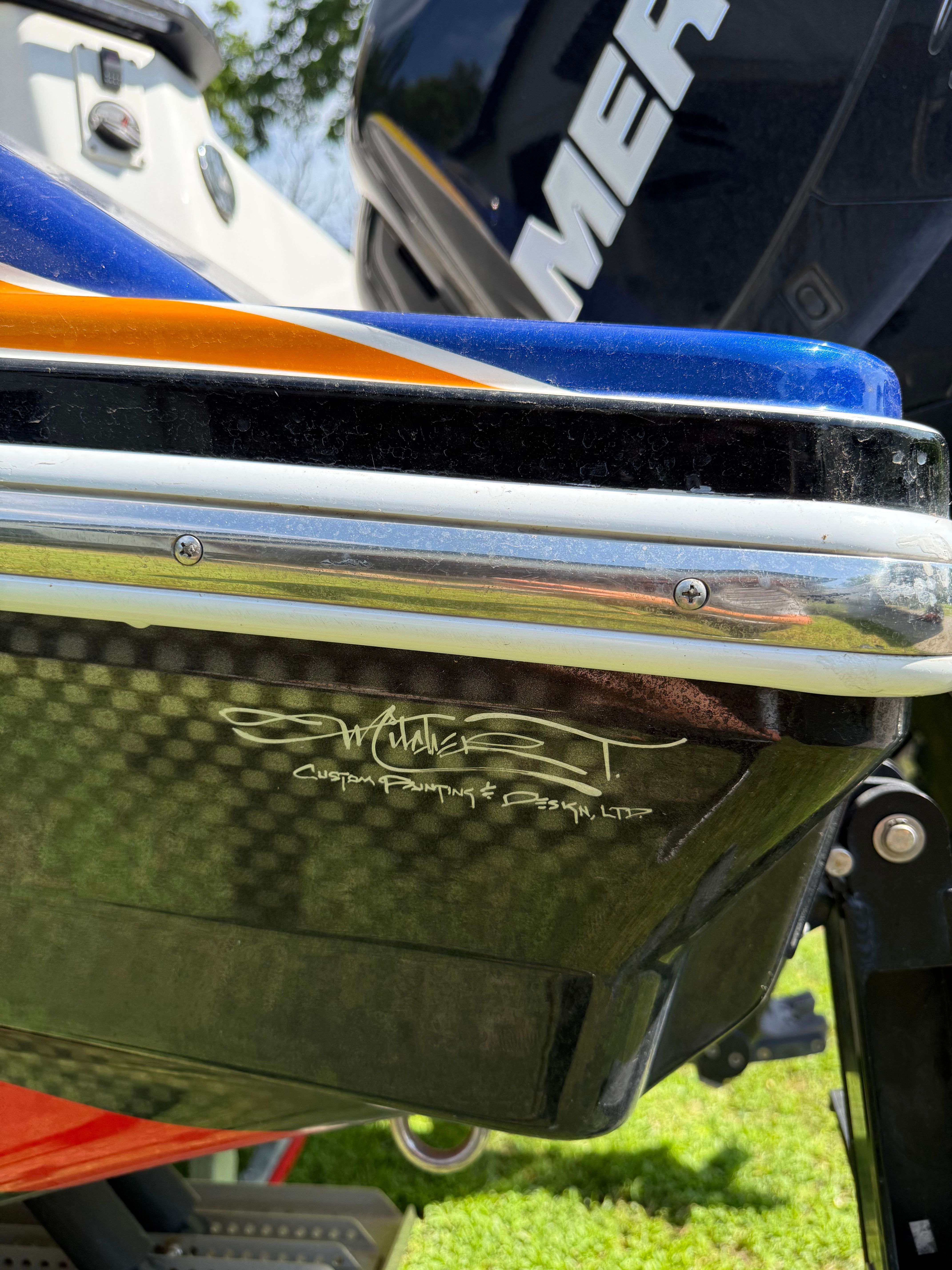 Close-up of a boat's stern with Mercury engine and custom design.
