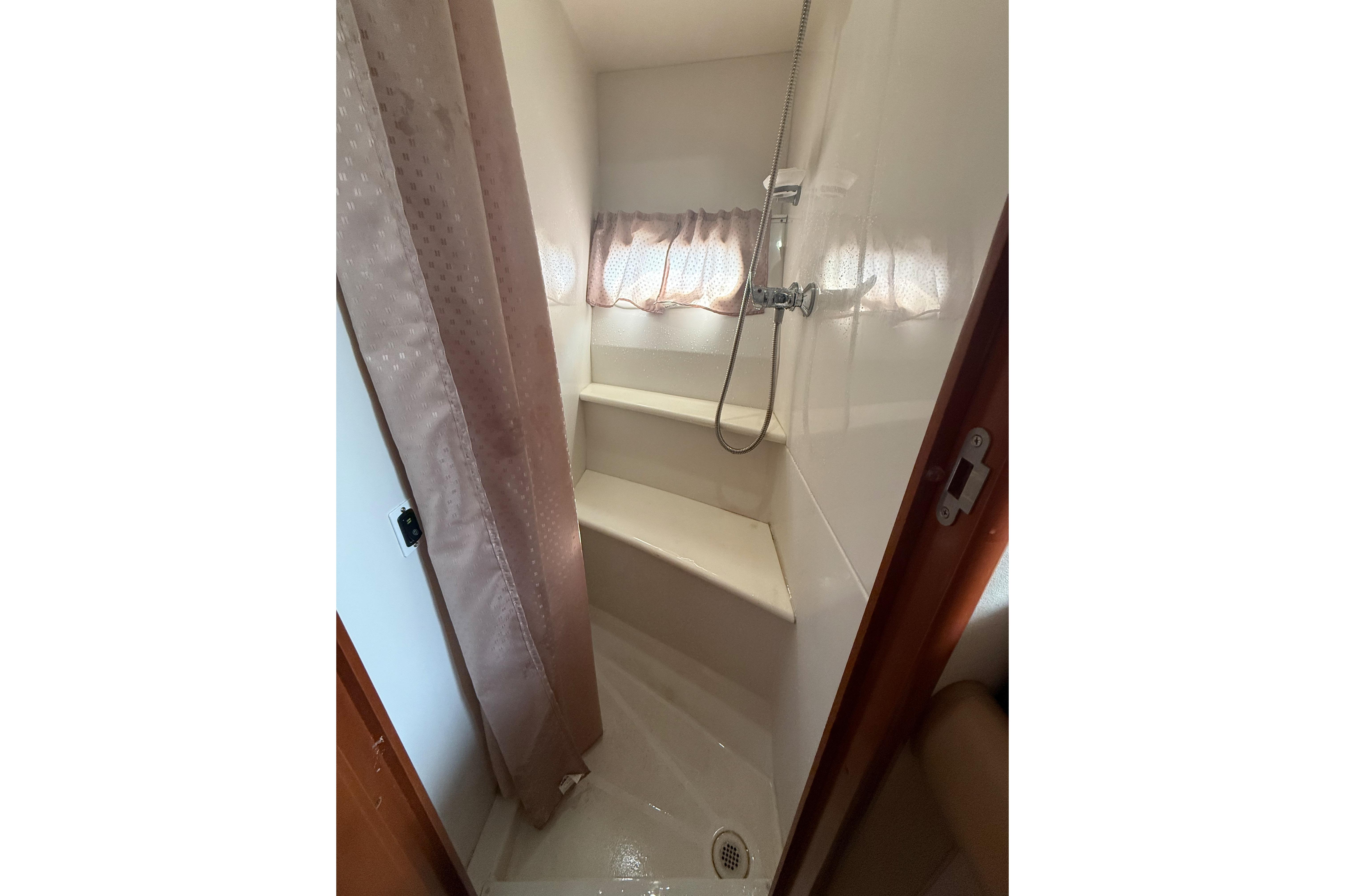Shower area in 2006 Carver 43 Motor Yacht with curtain and built-in seat.