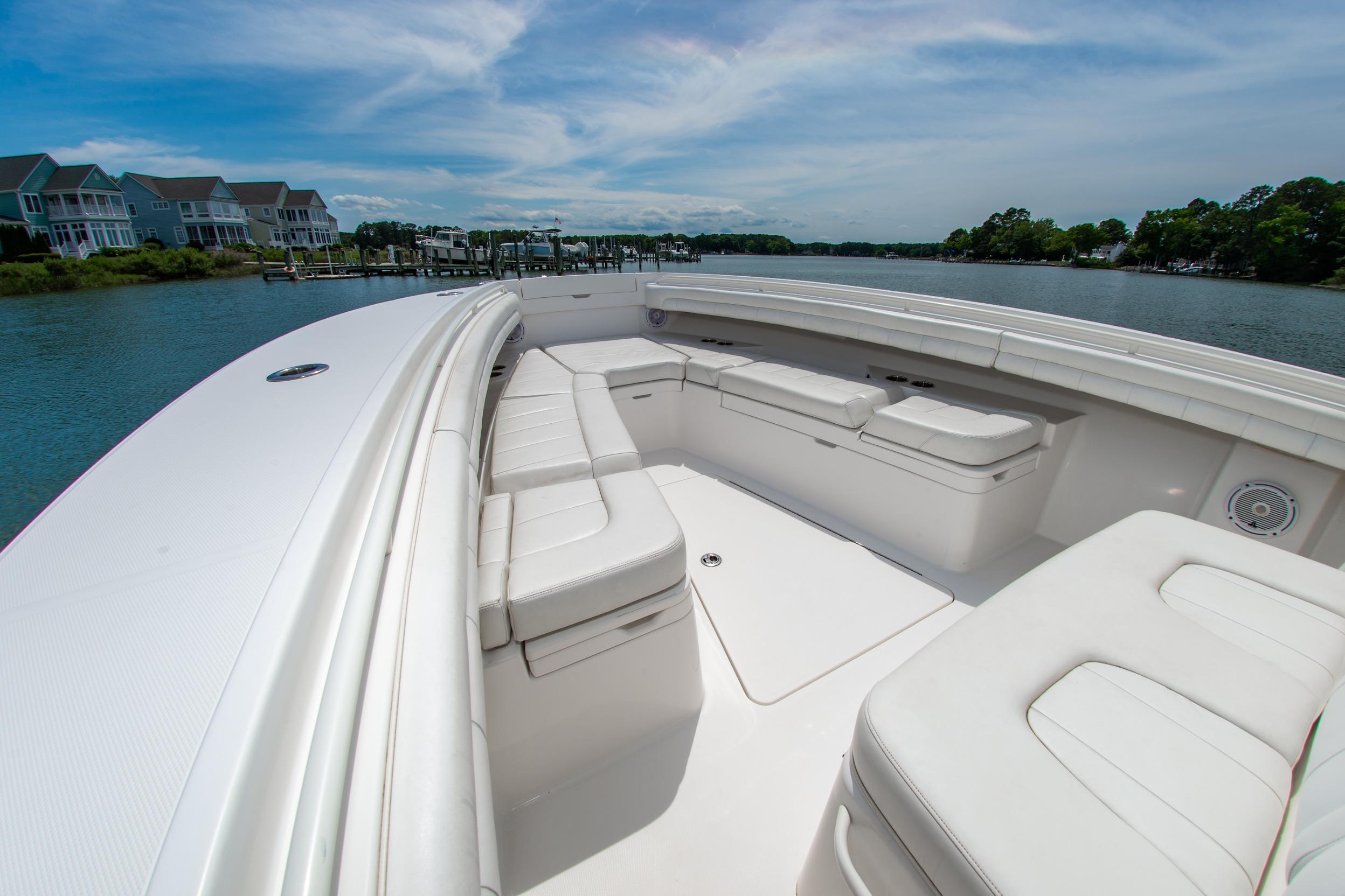 2019 Regulator 31 boat with spacious seating, docked near waterfront homes under a clear sky.