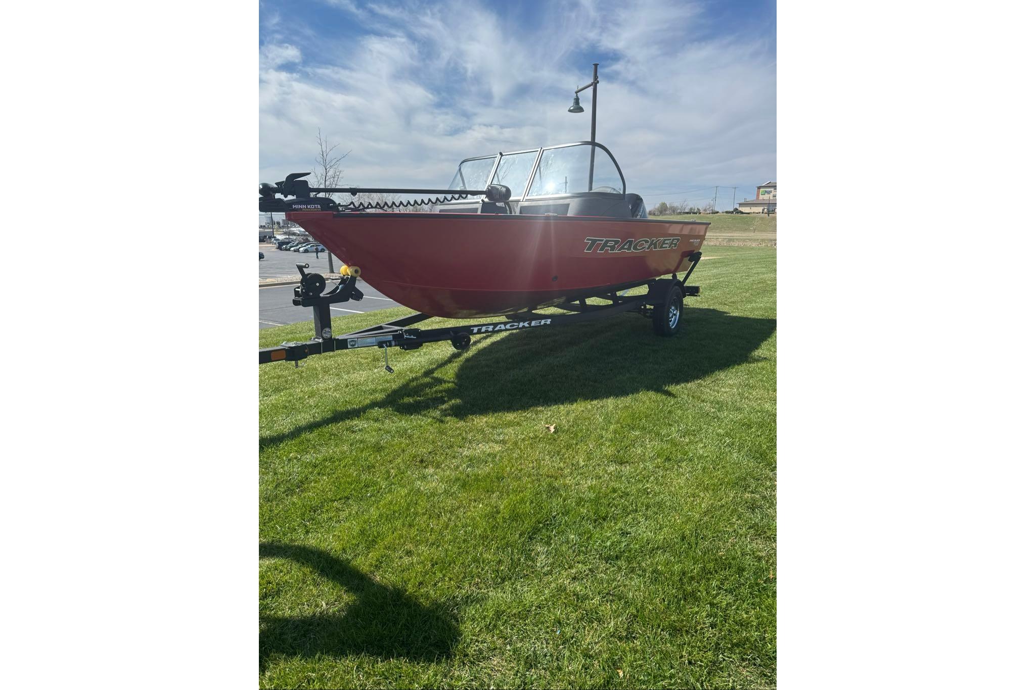 2026 Tracker Pro Guide V-16 WT boat on trailer, parked on grass.