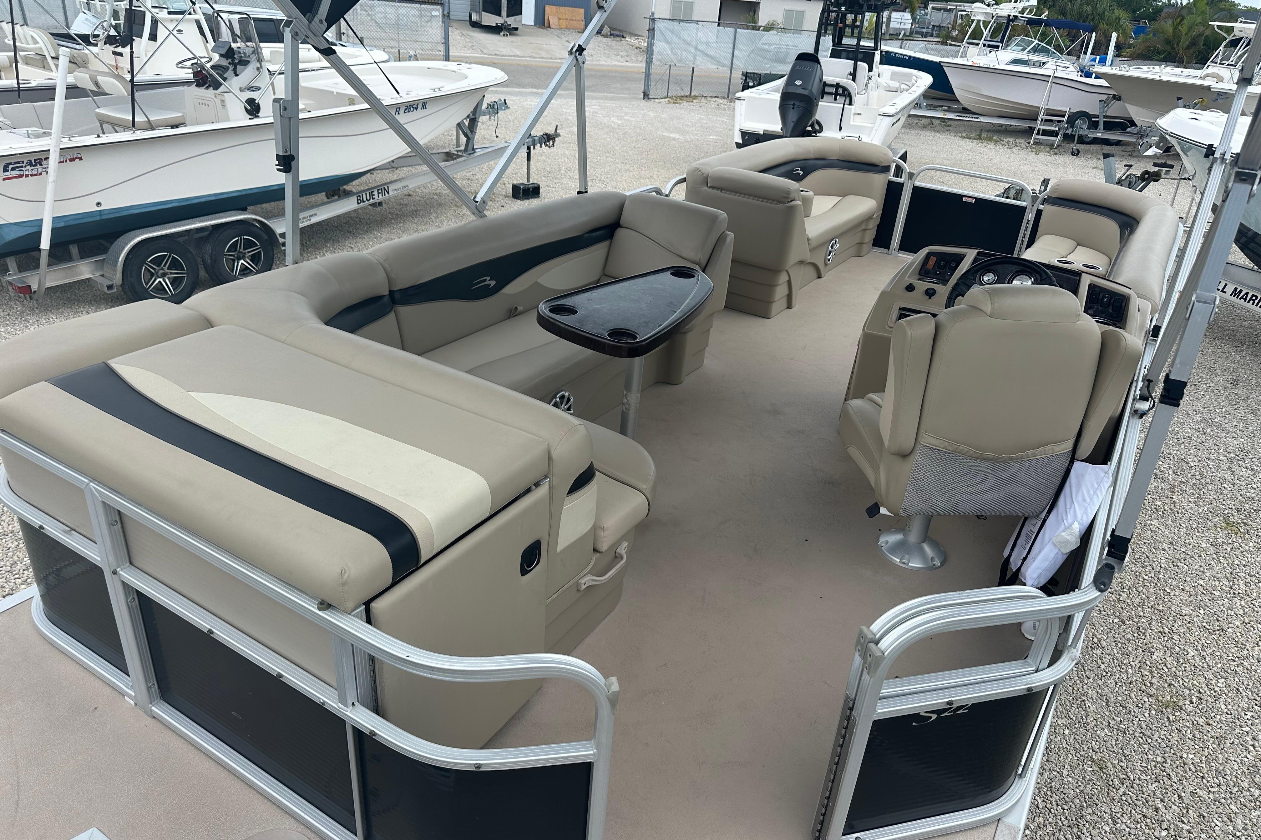 2014 Bennington S22 pontoon boat interior with beige seating and steering console.