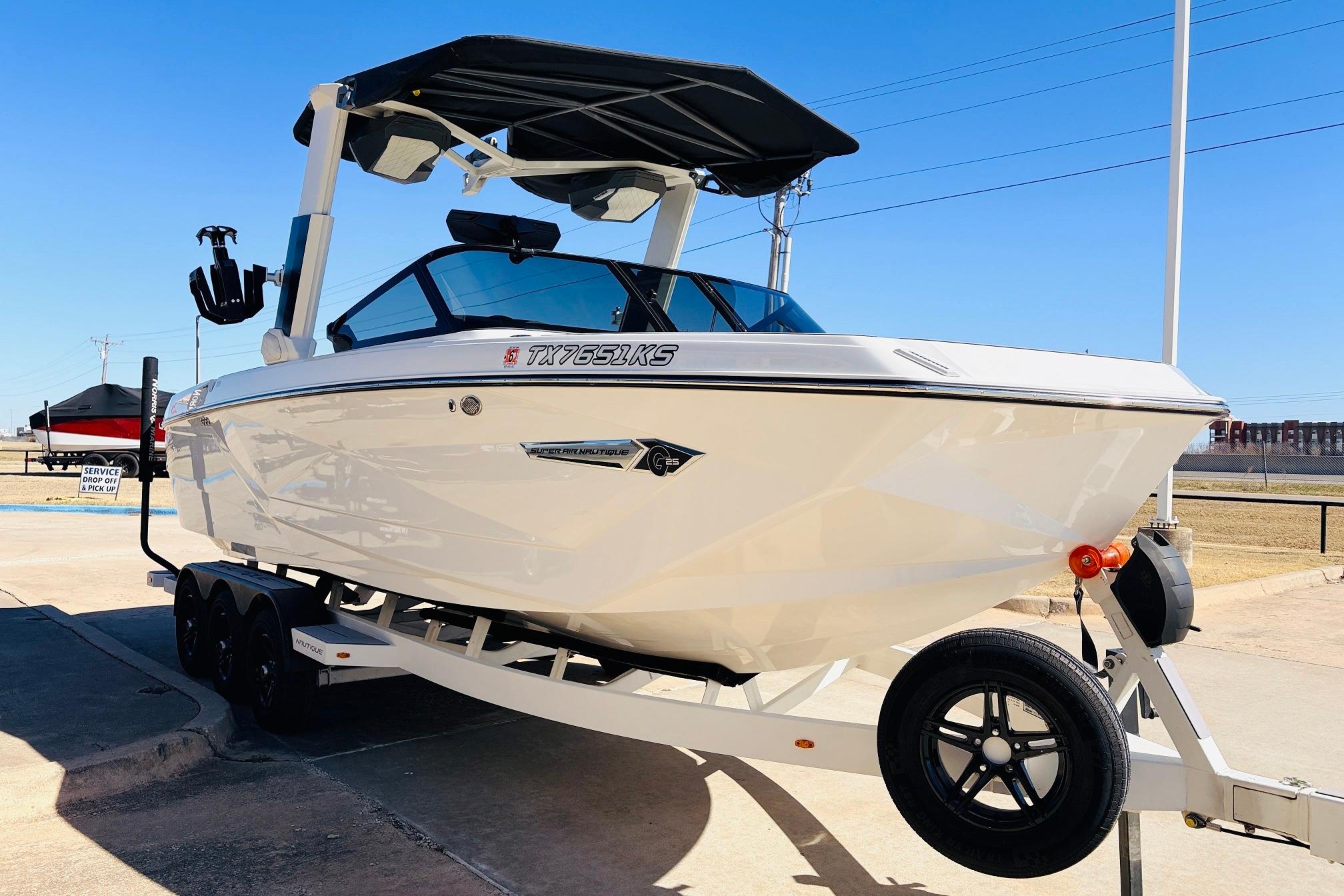 2023 Nautique Super Air Nautique G25 boat on trailer, parked outdoors.