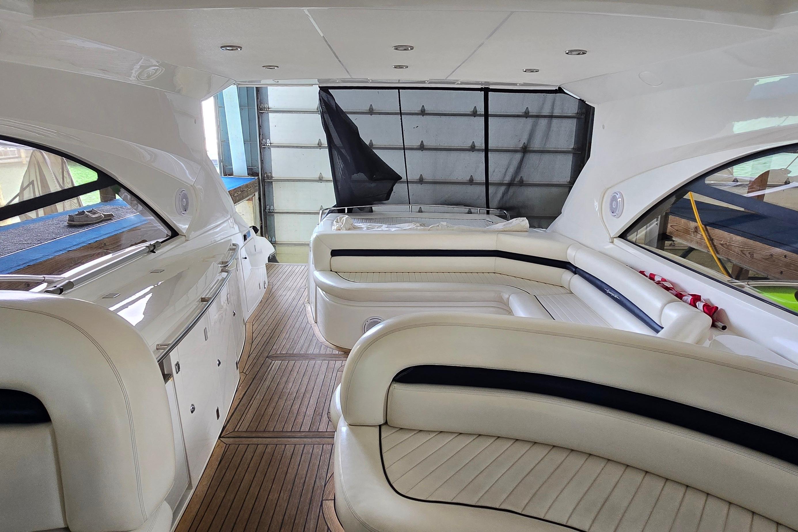 Interior of 2004 Sunseeker Camargue 50 yacht with elegant white seating and wood flooring.