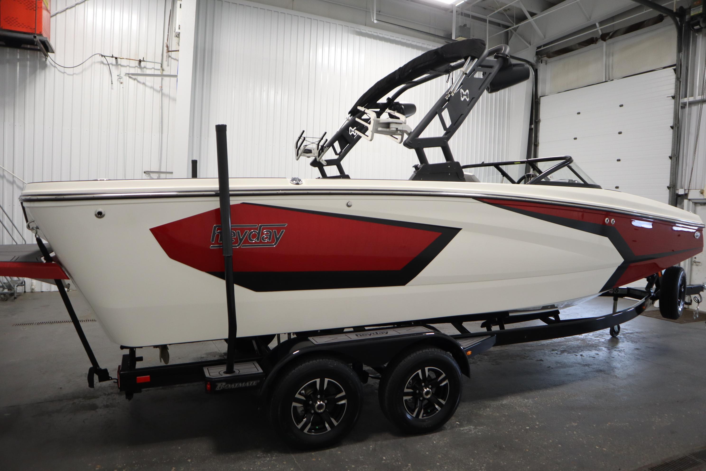2023 Heyday WT Surf boat in a garage, featuring a sleek red and white design.