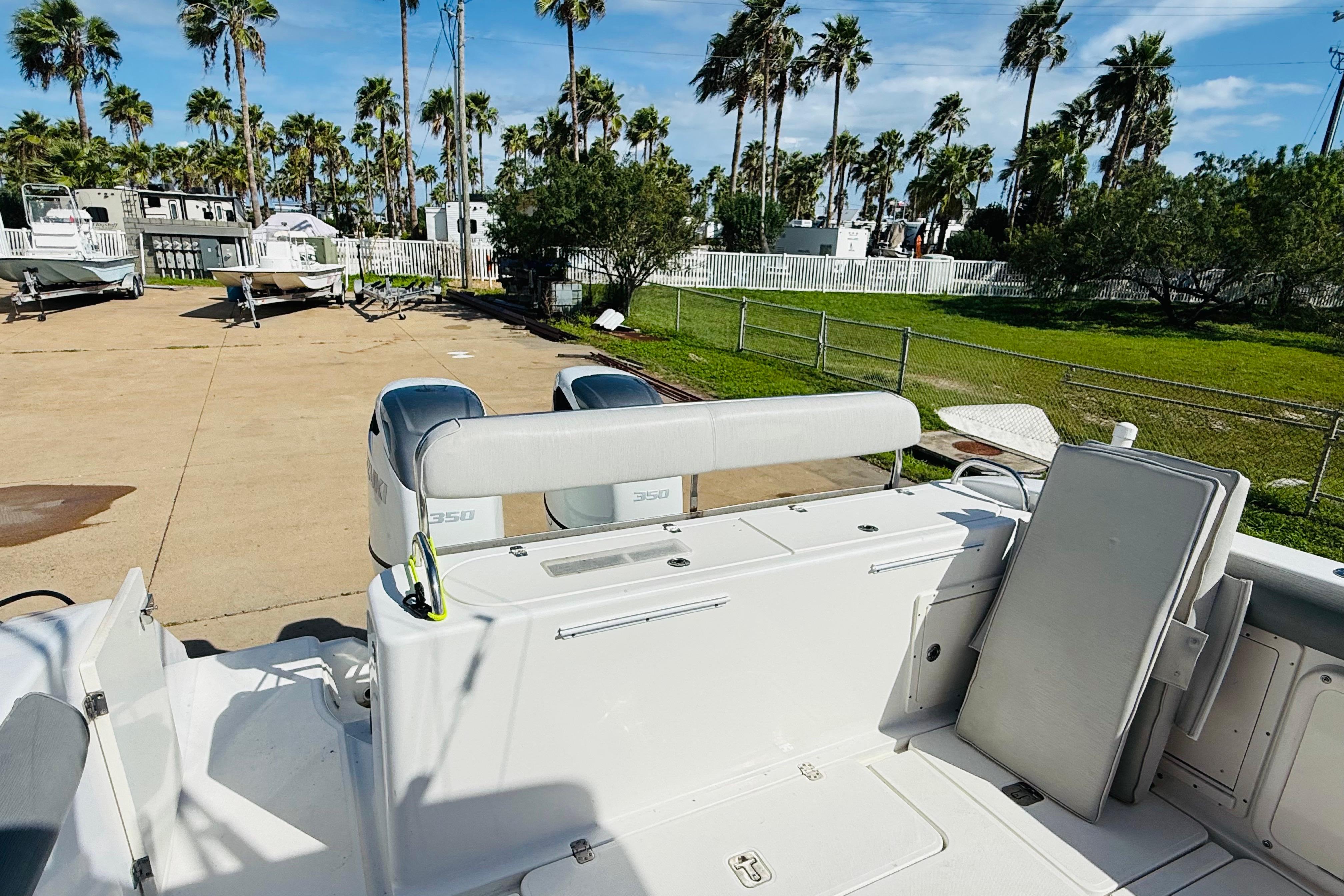 2005 Century 3200 Center Console boat with dual 350 engines, parked outdoors.