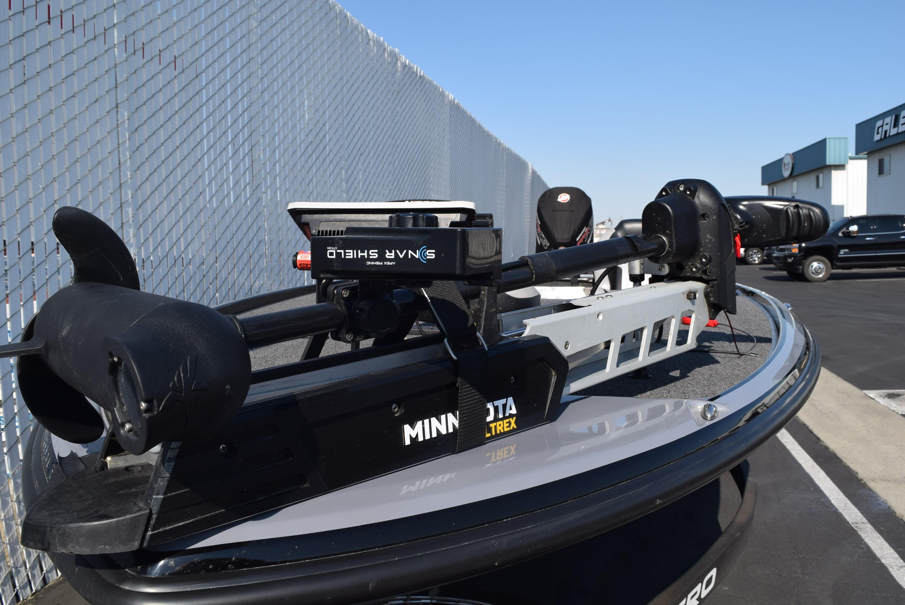 2025 Nitro Z20 XL Pro boat with Minn Kota Ultrex motor, parked near a chain-link fence.