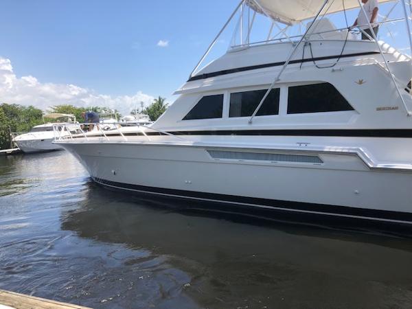 1997 Bertram Convertible yacht docked in a marina on a sunny day.
