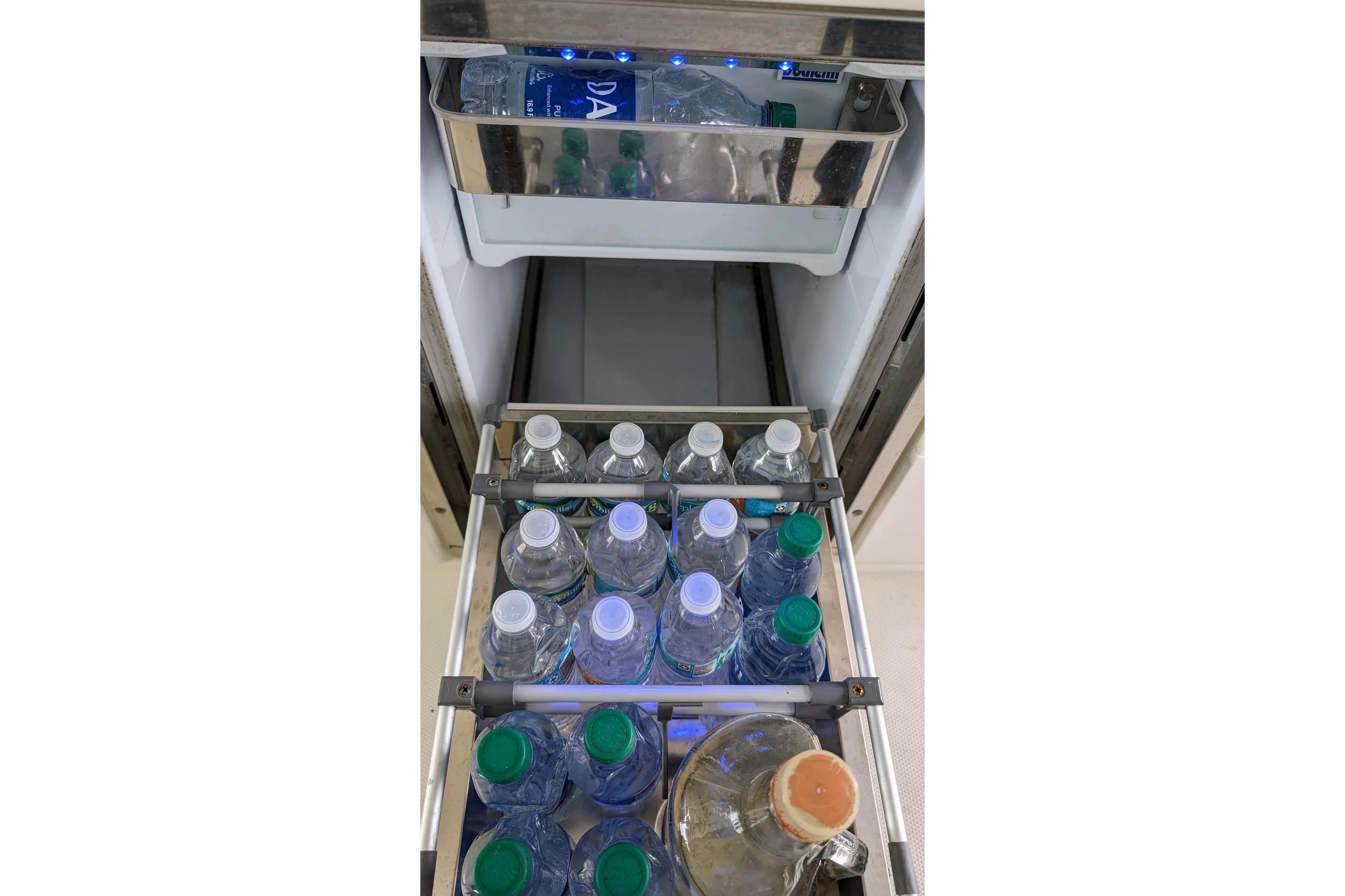 Refrigerator stocked with water bottles on a 2017 Boston Whaler 320 Vantage boat.