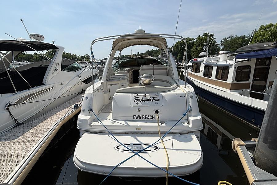 2002 Sea Ray Sundancer 320 docked at marina, rear view, sunny day.