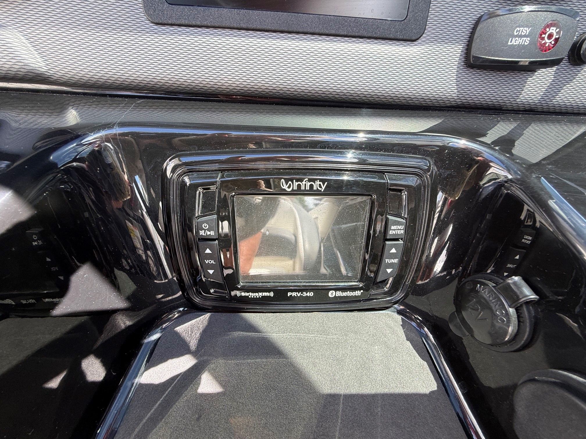 Close-up of a boat console display with controls and a screen.