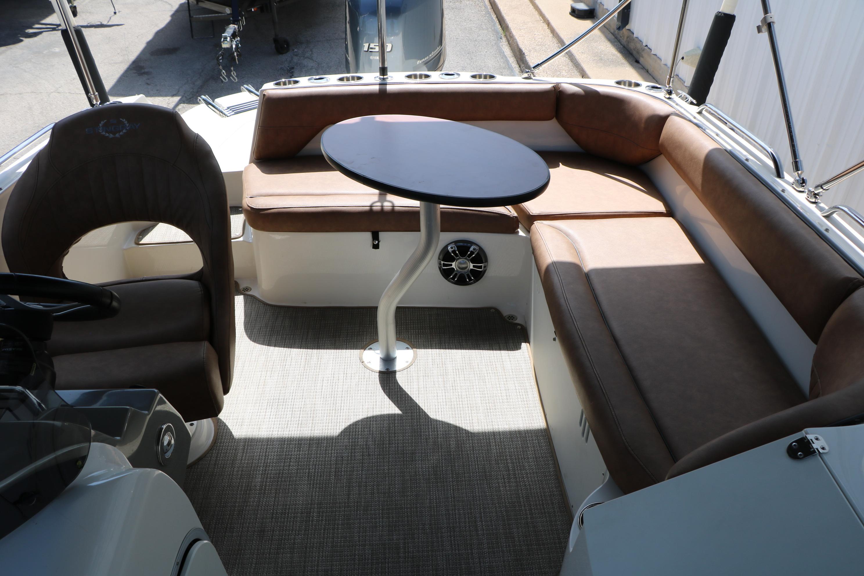 2022 Stingray 192 SC boat interior with brown seating and a central table.
