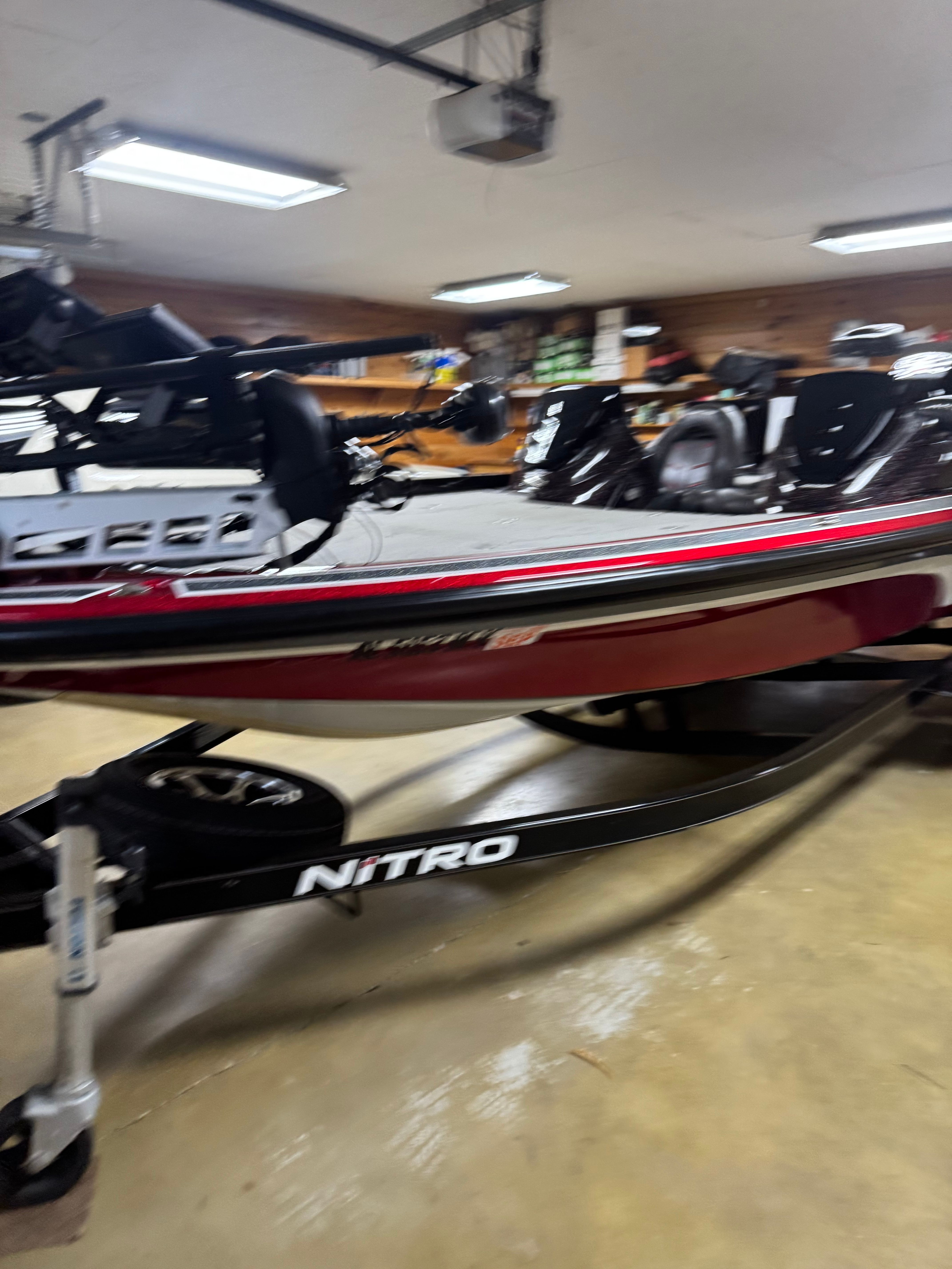A red Nitro Z21 boat is in a garage on a trailer.