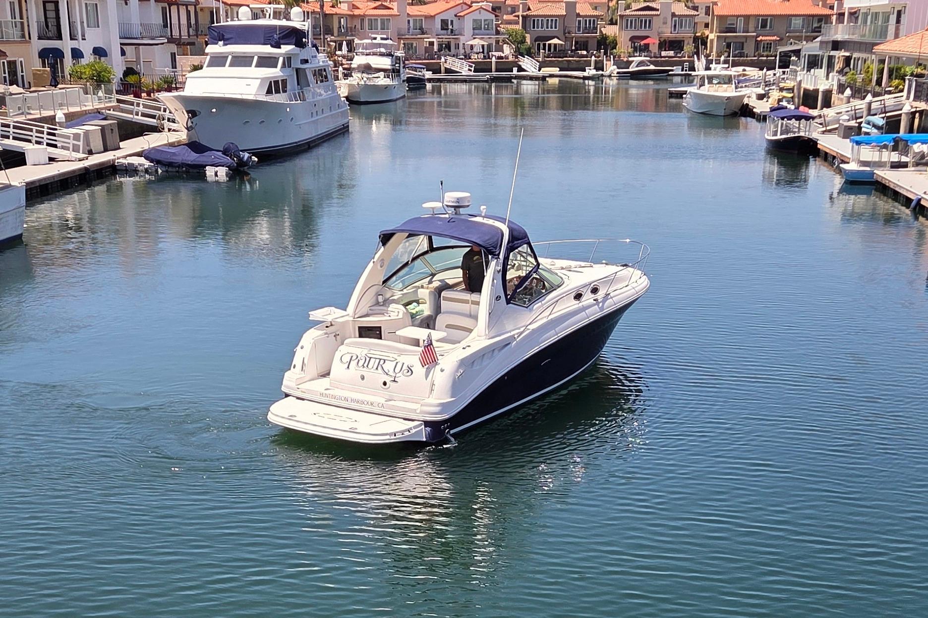 2006 Sea Ray Sundancer 320 yacht cruising in a serene marina setting.
