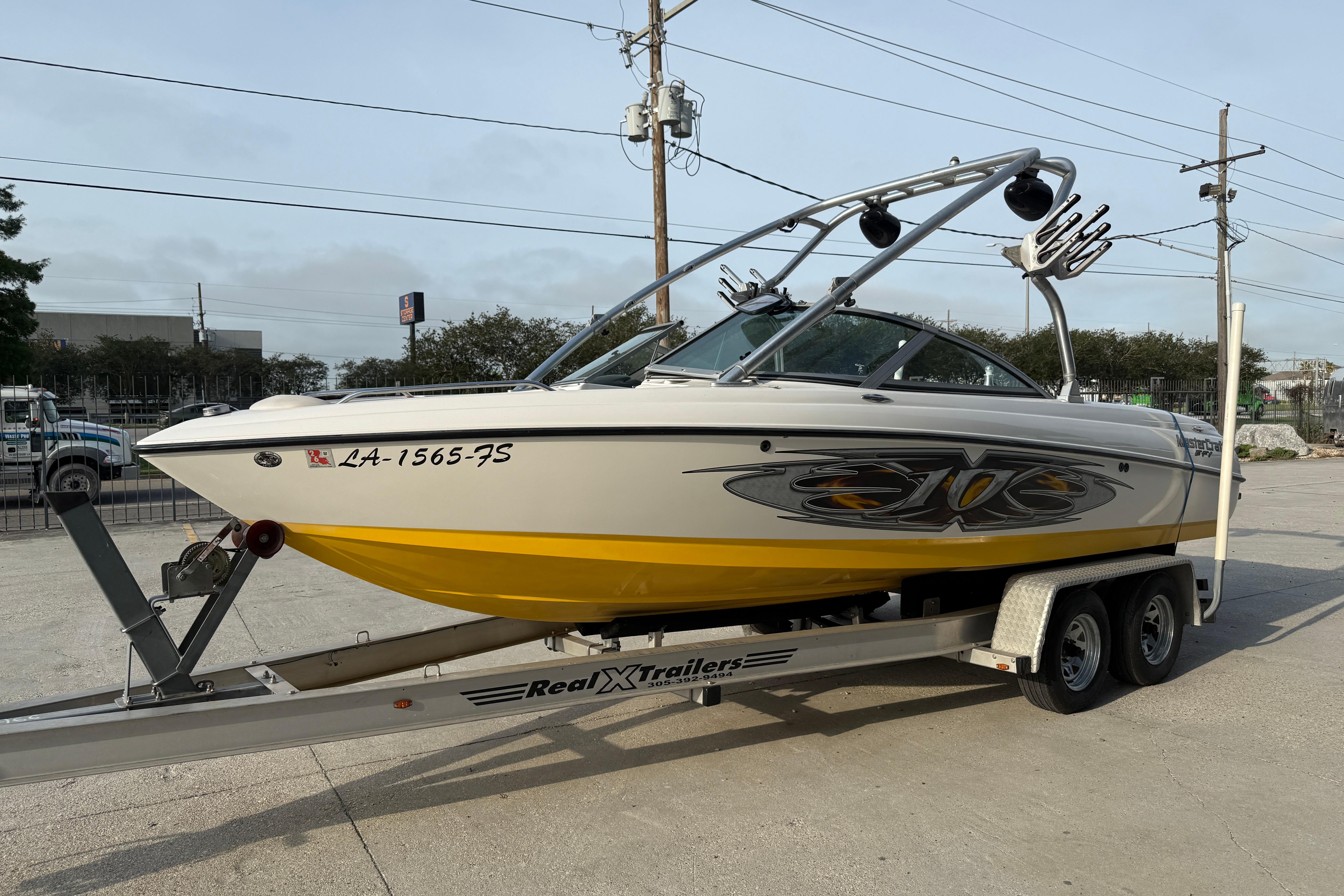 2005 MasterCraft X10 boat on trailer, featuring sleek design and vibrant yellow accents.