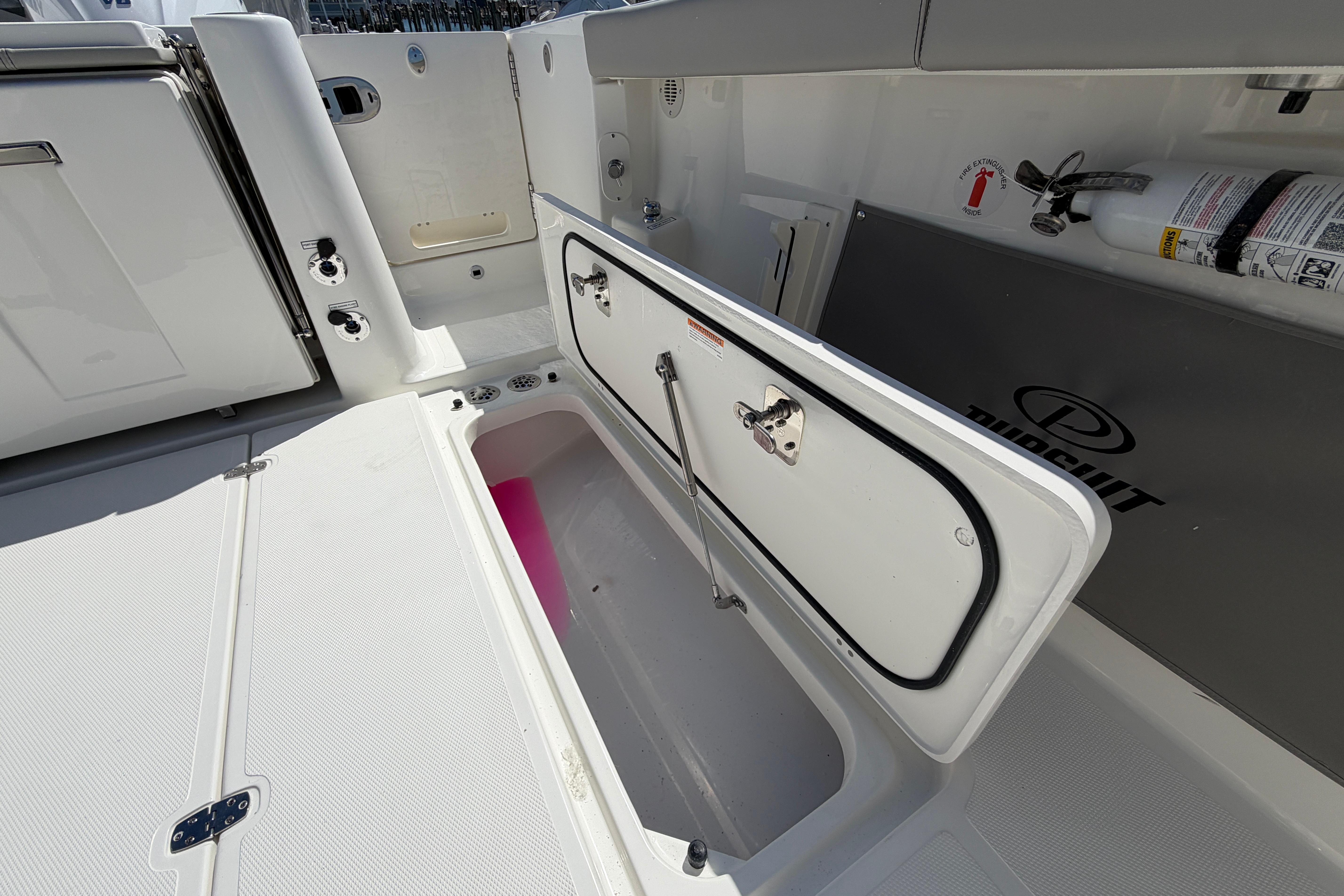 2026 Pursuit S 358 Sport boat interior with open storage compartment and safety equipment.